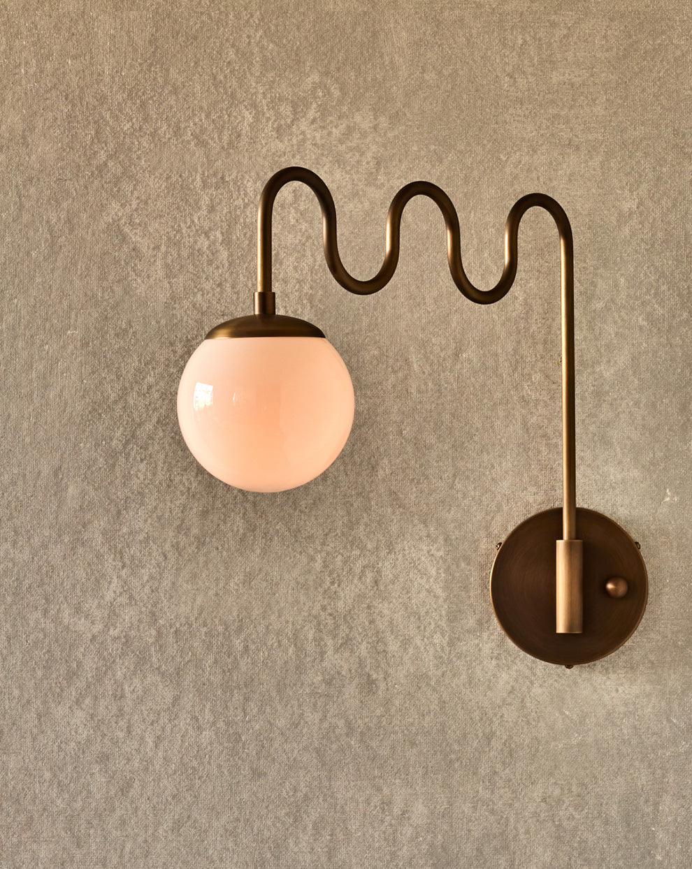 Angled view of the Cecil Wall Sconce with milk glass globe.