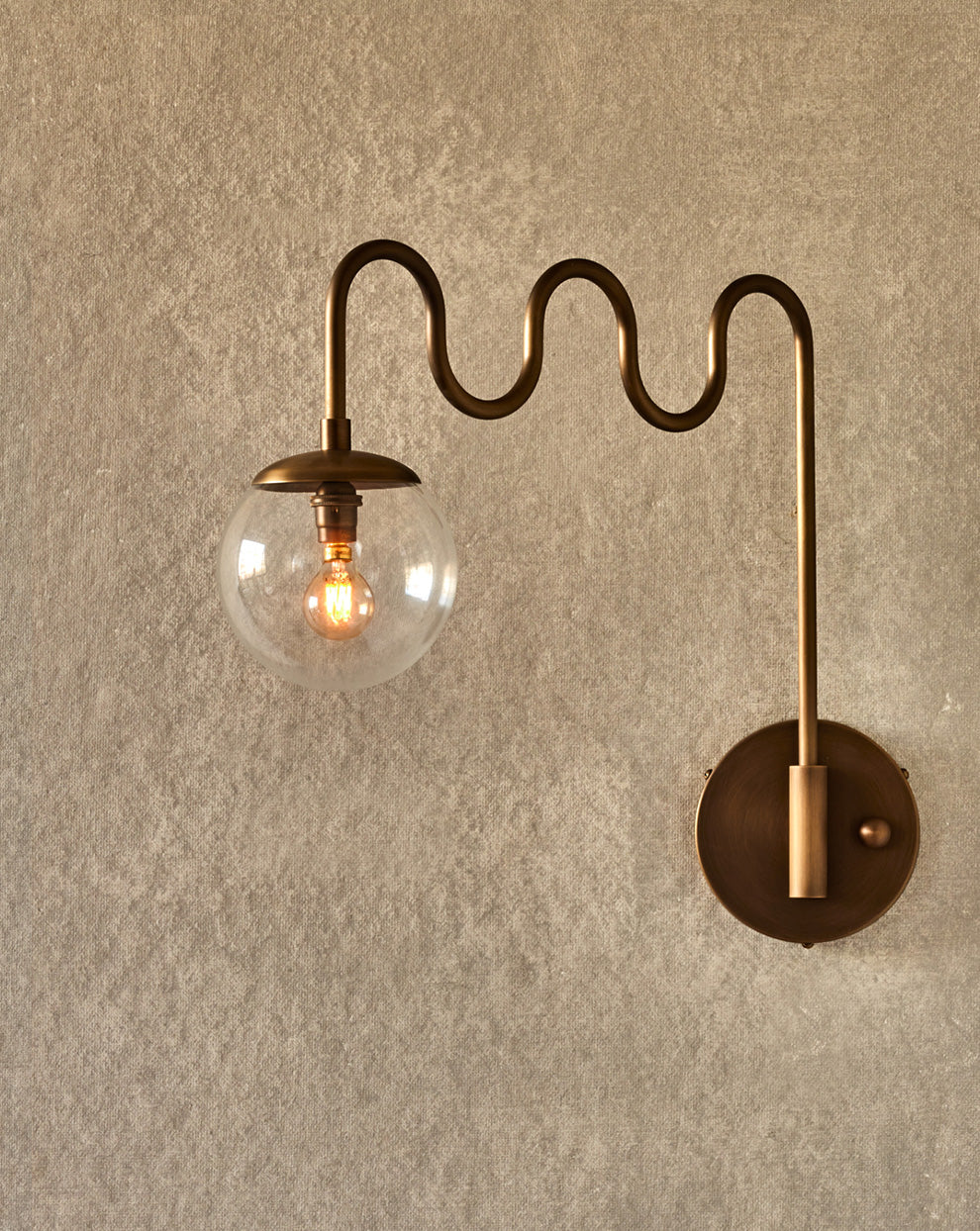 Angled view of the Cecil Wall Sconce with clear glass globe.