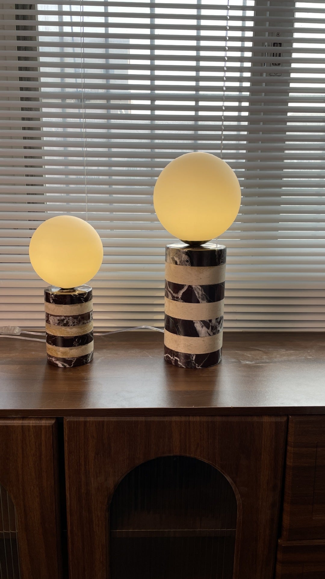 Close-up of the Charade Table Lamp's handcrafted brown marble base showing natural veining.