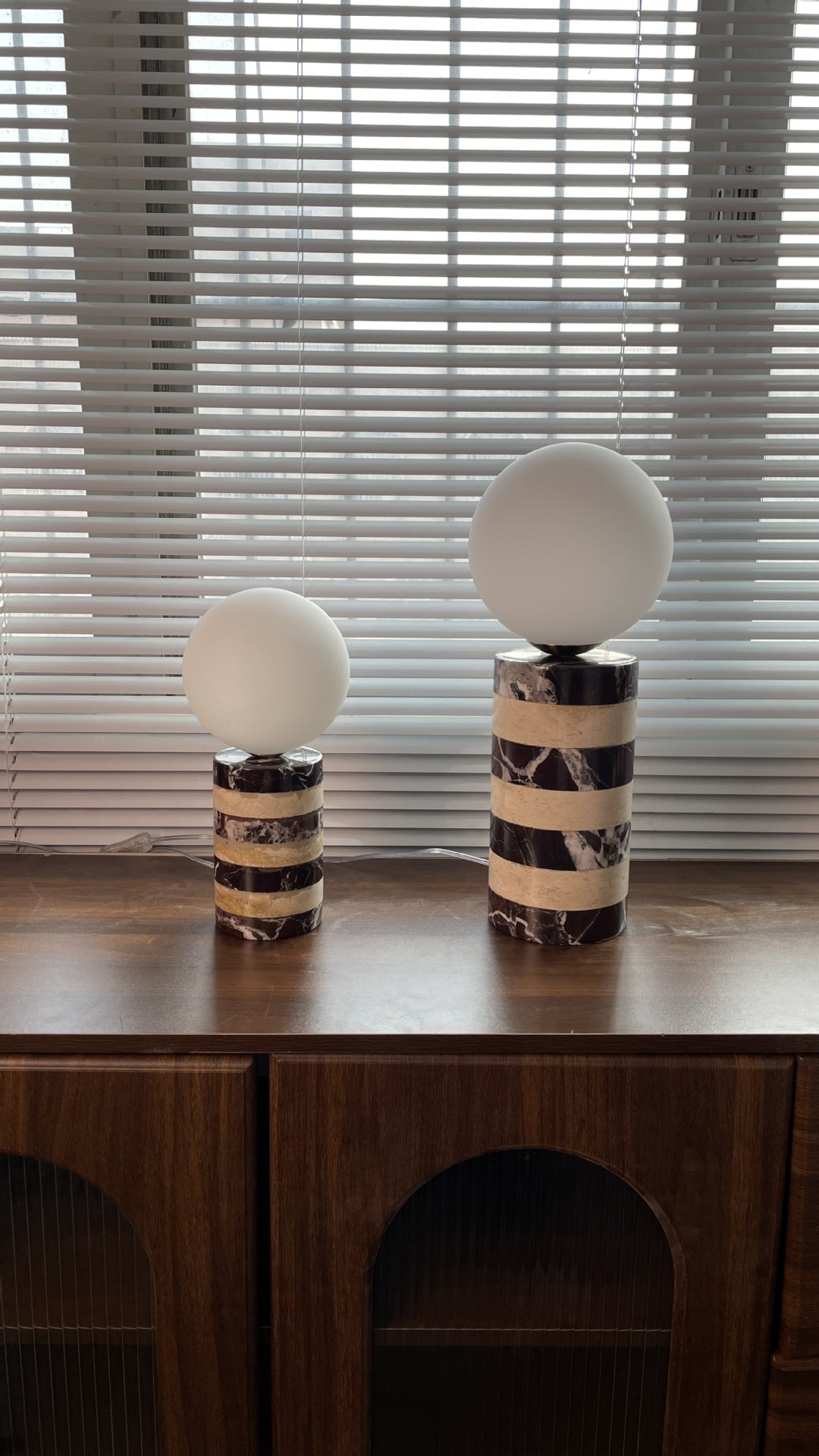 Both sizes of the Charade Marble Table Lamp, in white and brown, shown side-by-side.