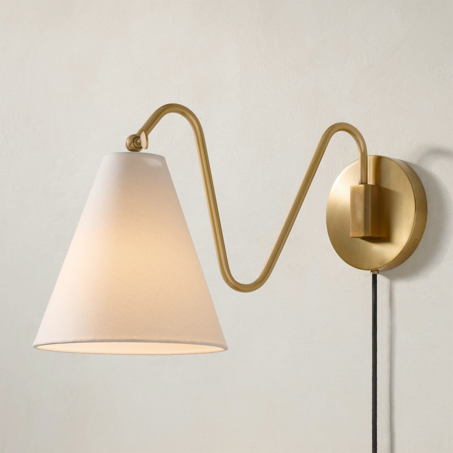 Angled view of the one-head Cleome wall lamp in brass.