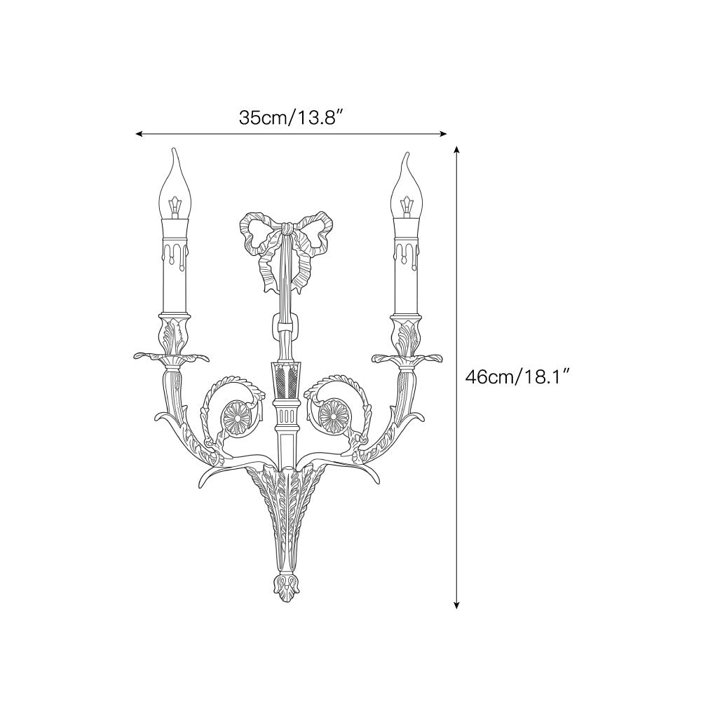 Close-up of the delicate ribbon bow crest on the brass wall sconce.