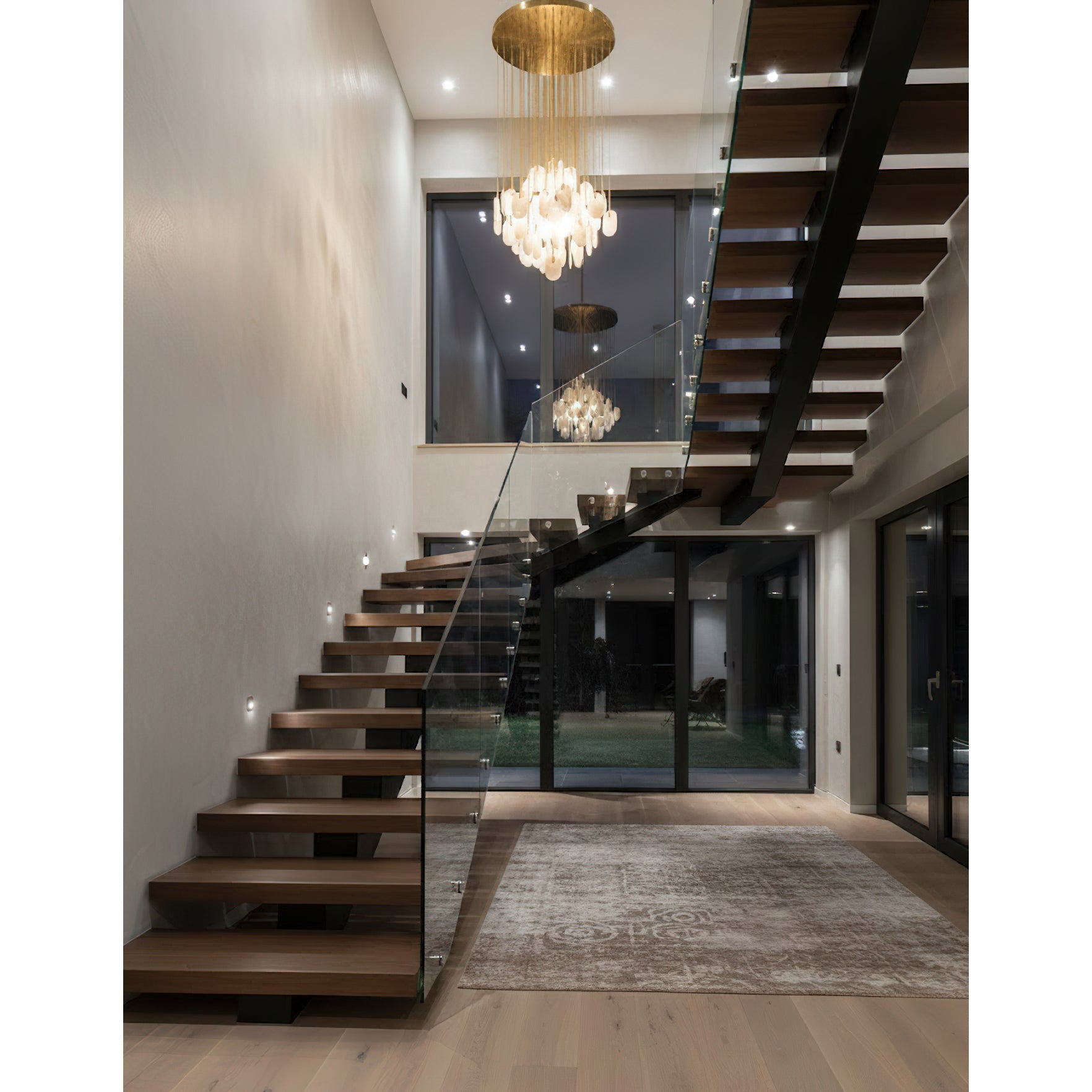 The chandelier installed in a modern, double-height great room.
