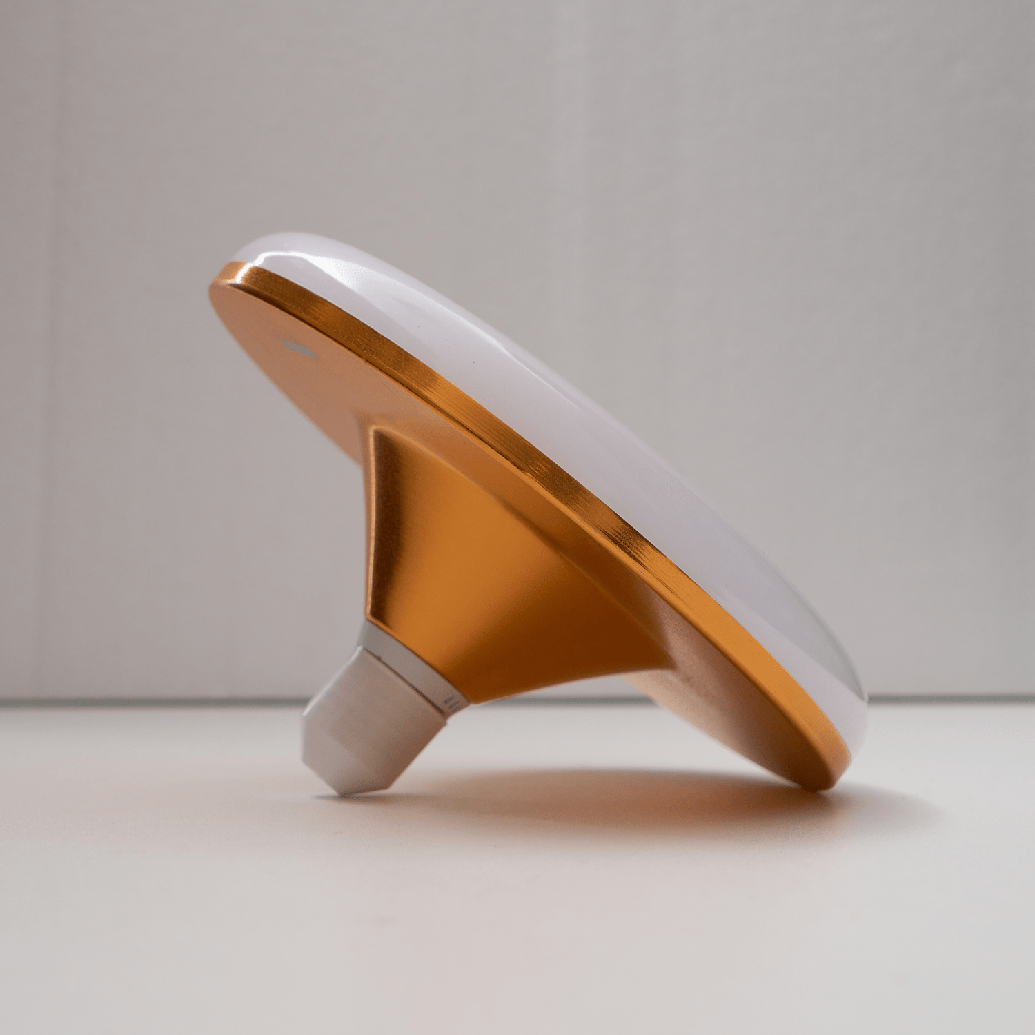 Close-up view of the modern white disc shape of the flying saucer LED bulb.