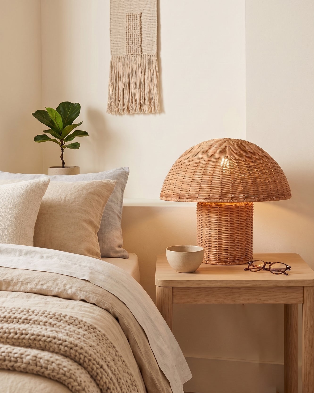 The Aero Rattan Mushroom Table Lamp illuminating a dark room.
