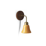 Daphne Pastel Plug-In Wall Sconce with orange glass shade and walnut backplate.