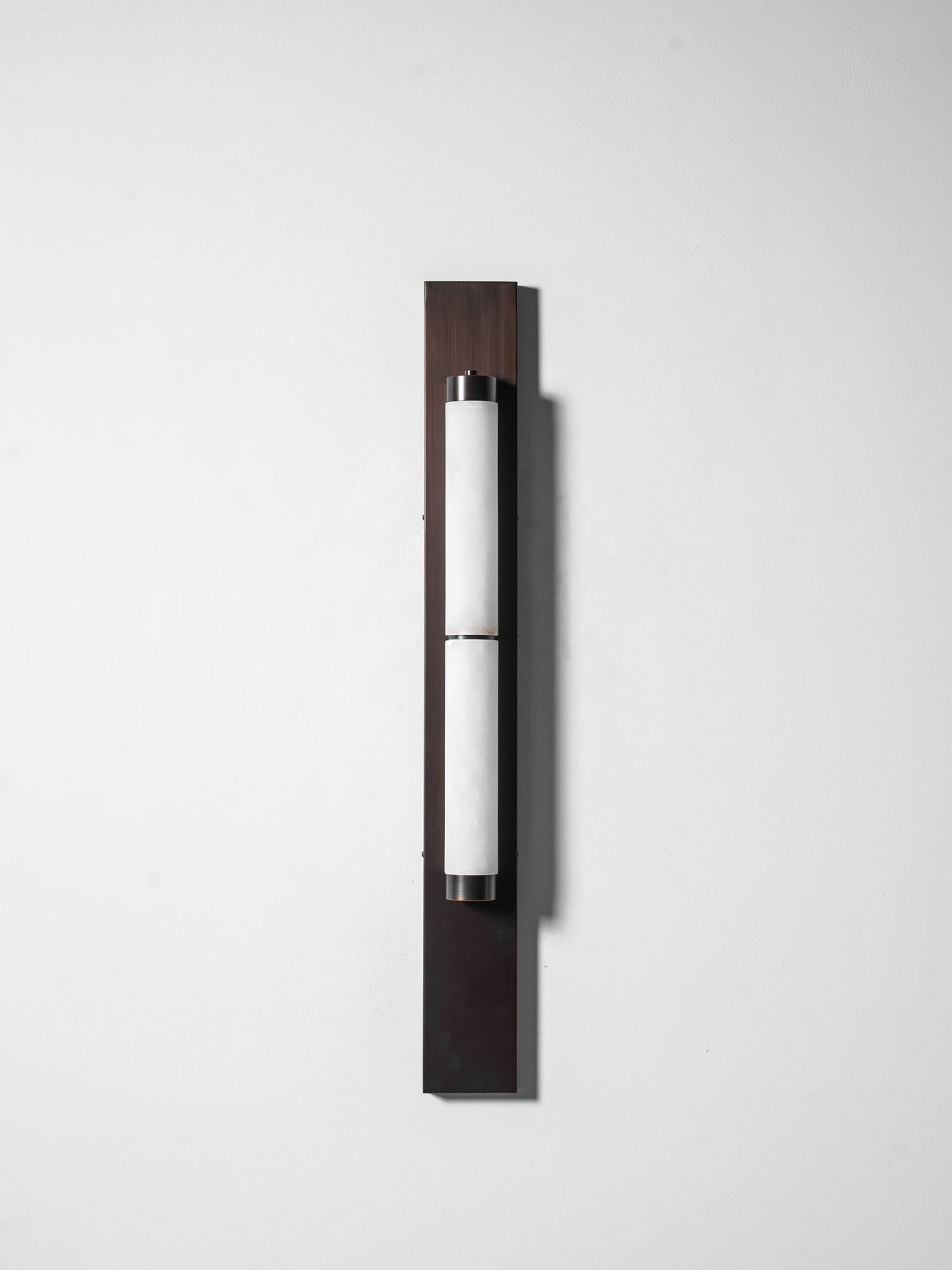 The brass backplate of the Columnar Alabaster Wall Lamp.