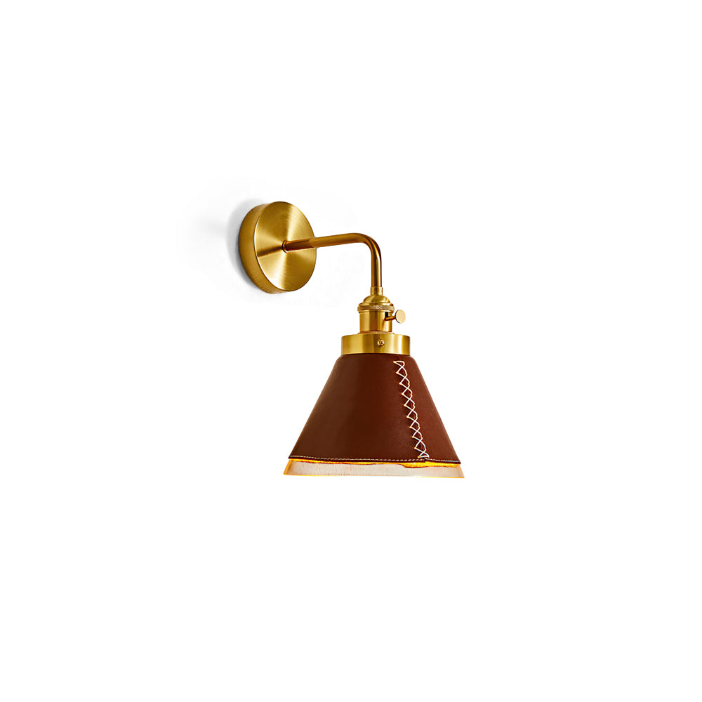 Cordoba Wall Sconce in brown leather and gold metal against a plain wall.