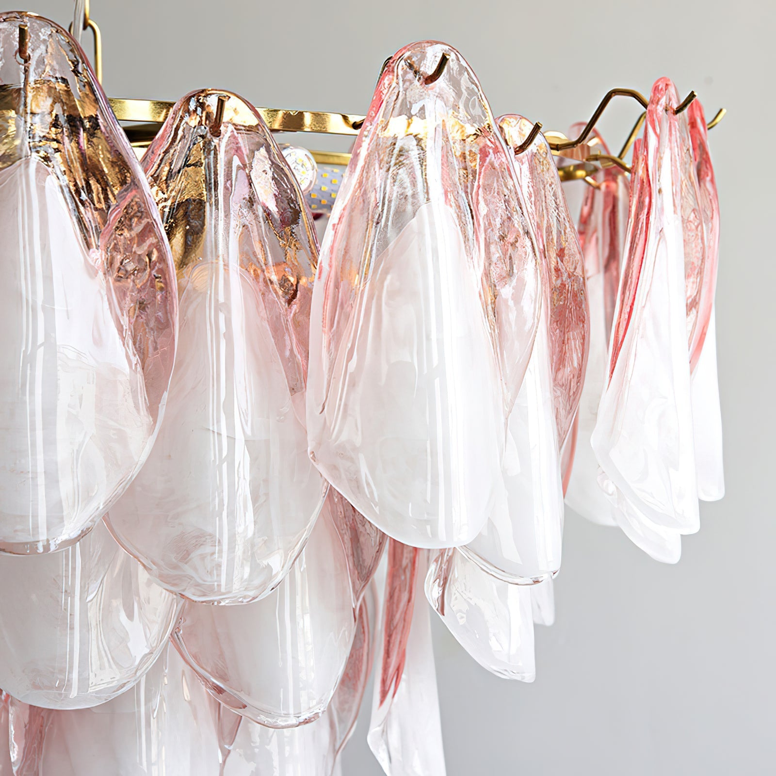 The chandelier illuminated, casting a warm and inviting glow through the glass leaves.
