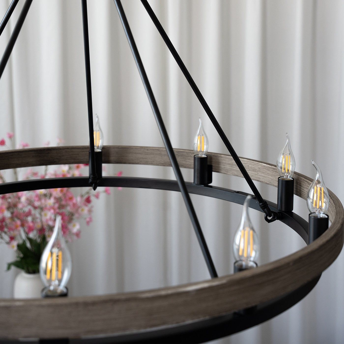 Detail view of the black metal and walnut finish of the chandelier.
