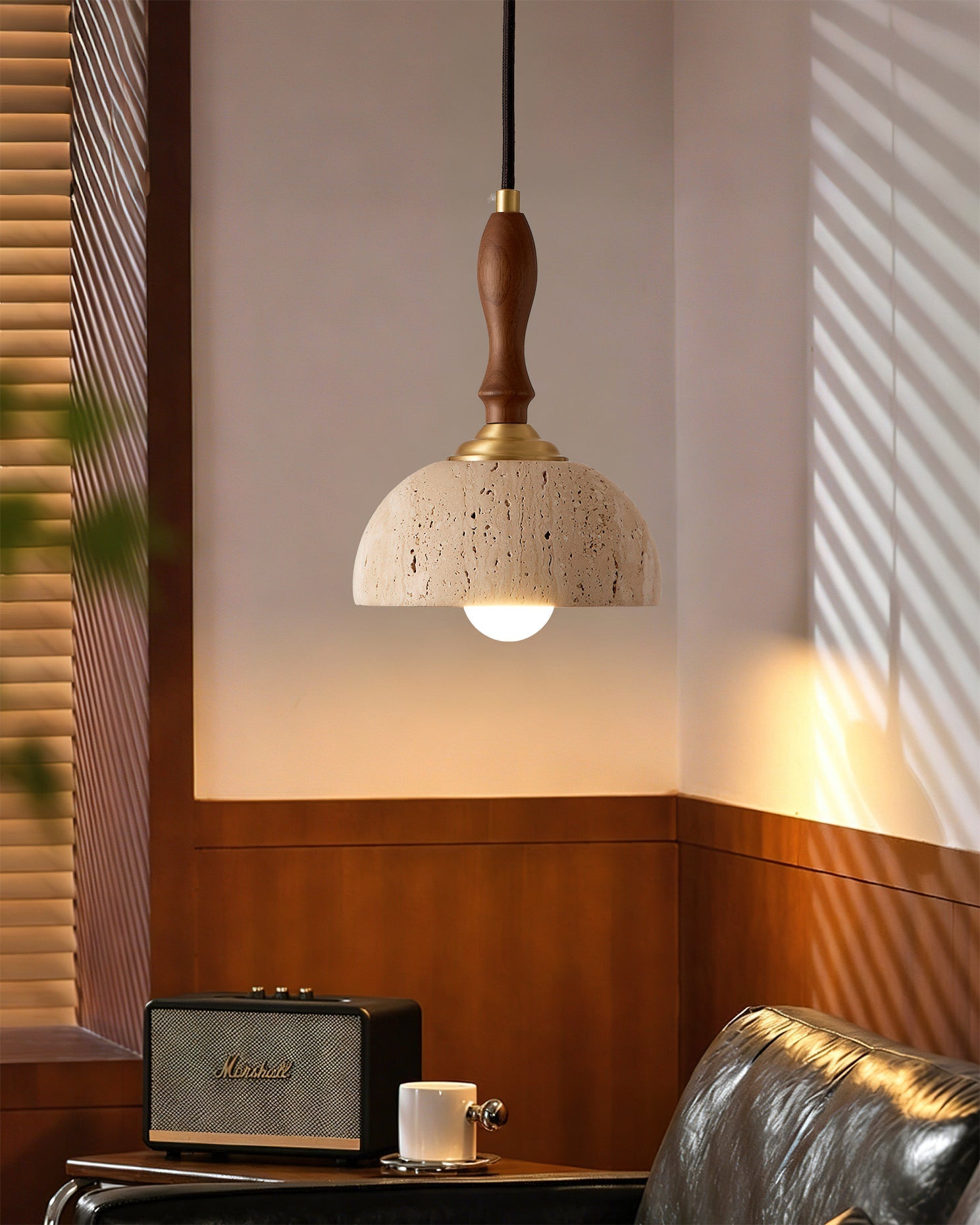 Close-up of the Enora pendant light showing the travertine shade and wooden stem.