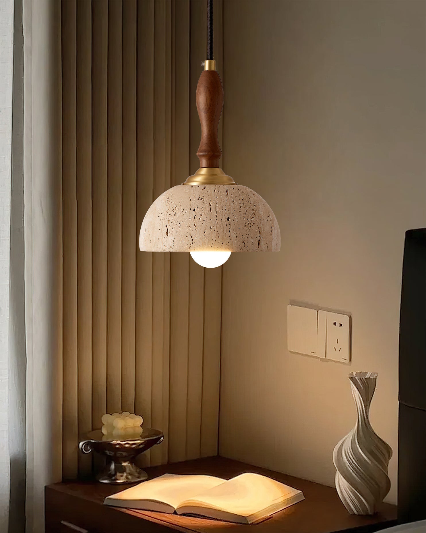 A single Enora pendant light providing ambient light next to a bed.