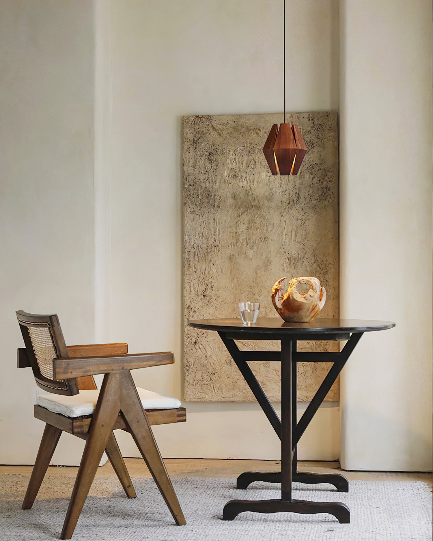 The Kaden Wood Pendant Light suspended over a small dining table.