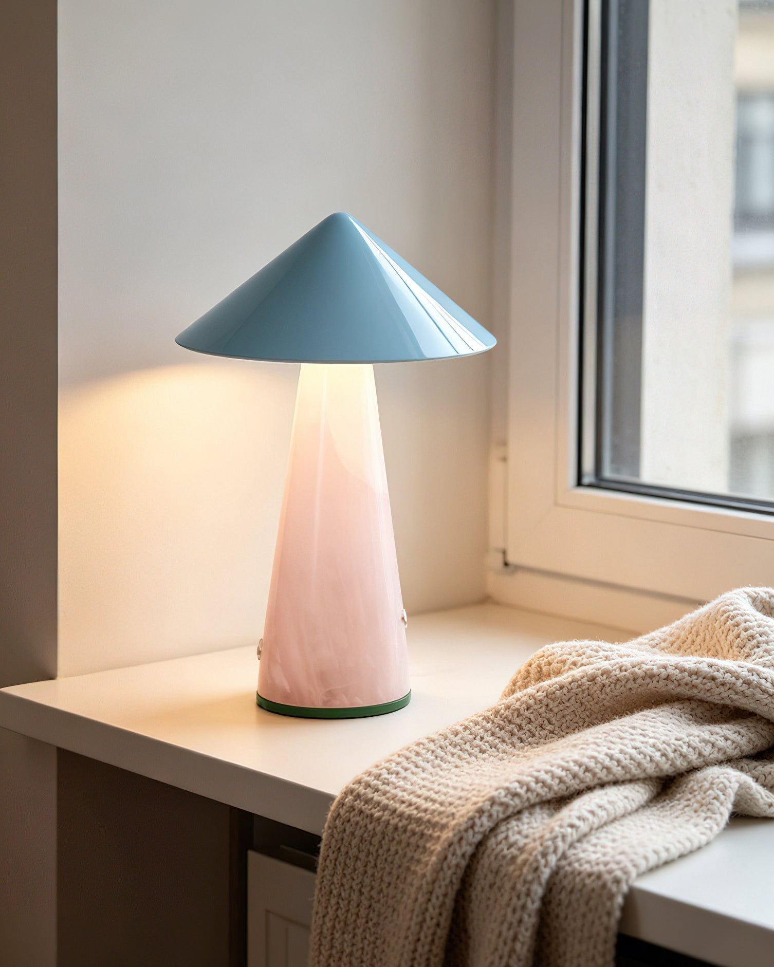 The blue Maisie lamp shown on a bedside table, providing a cozy light.