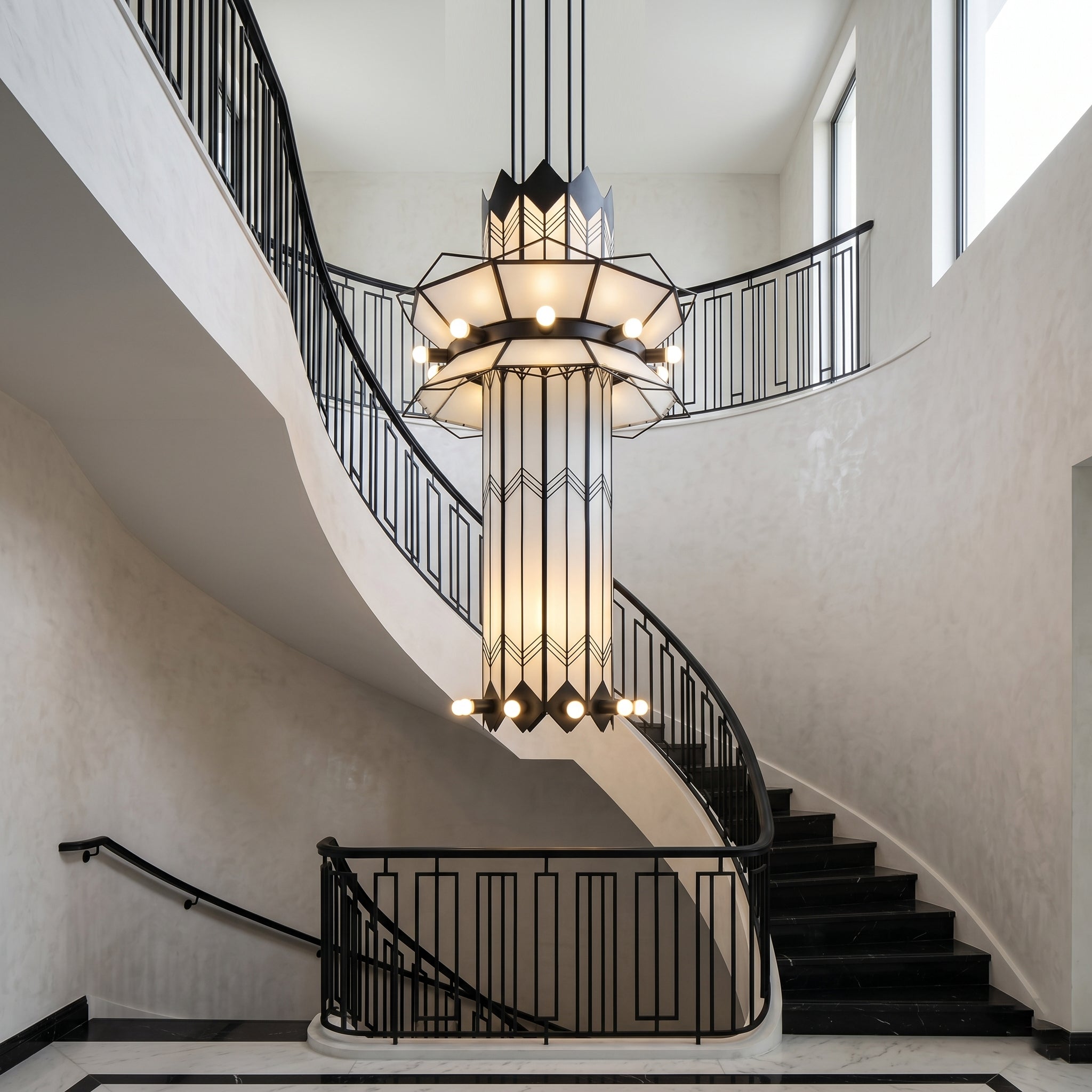 The Manhattan Ziggurat Chandelier shown in a white finish against a dark wall.