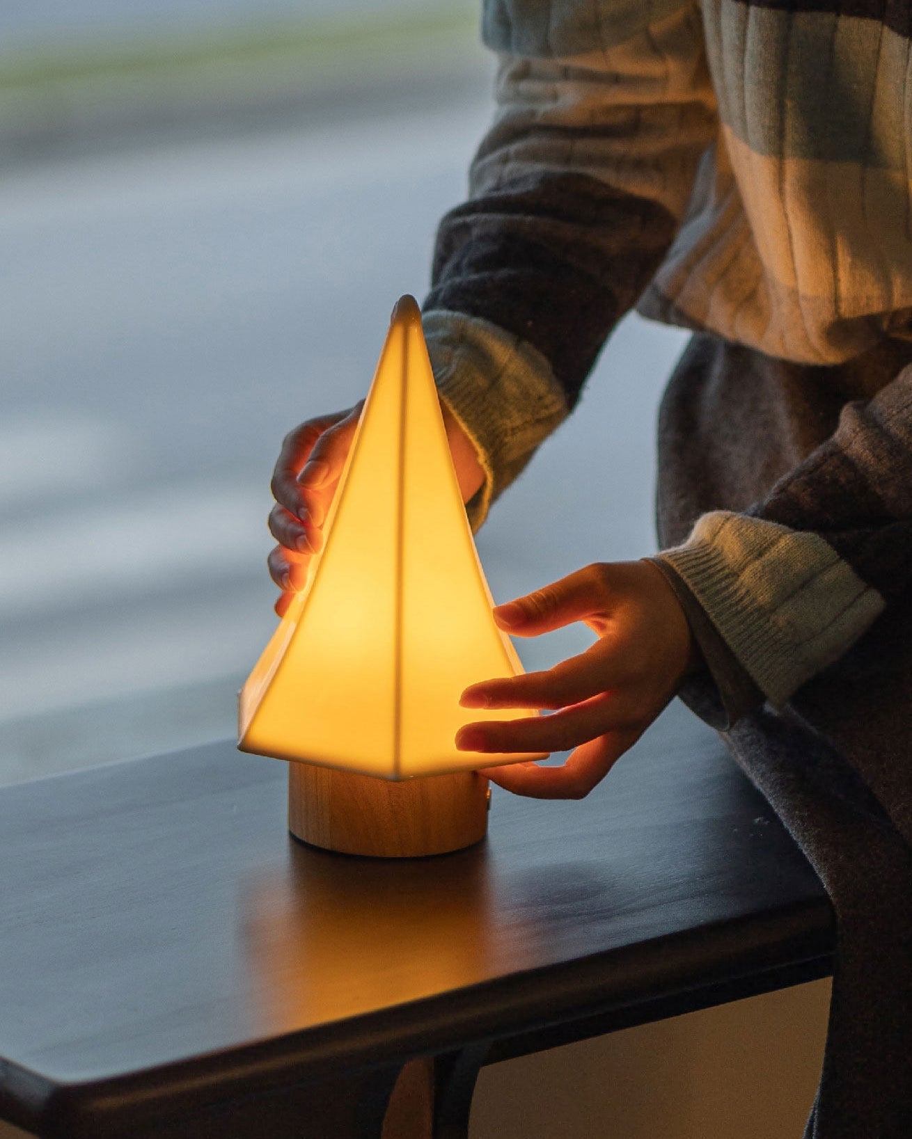 Close-up of the natural wood base and ceramic details of the Orlo lamp.