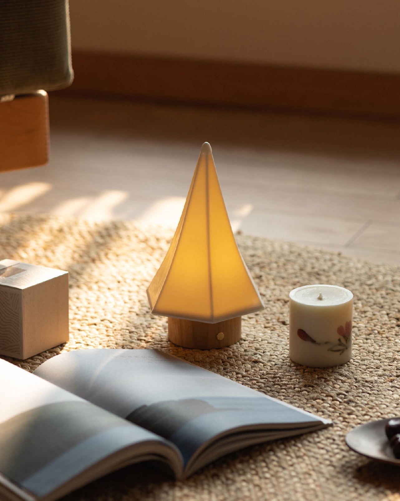 The Orlo Table Lamp glowing softly on a bedroom nightstand.