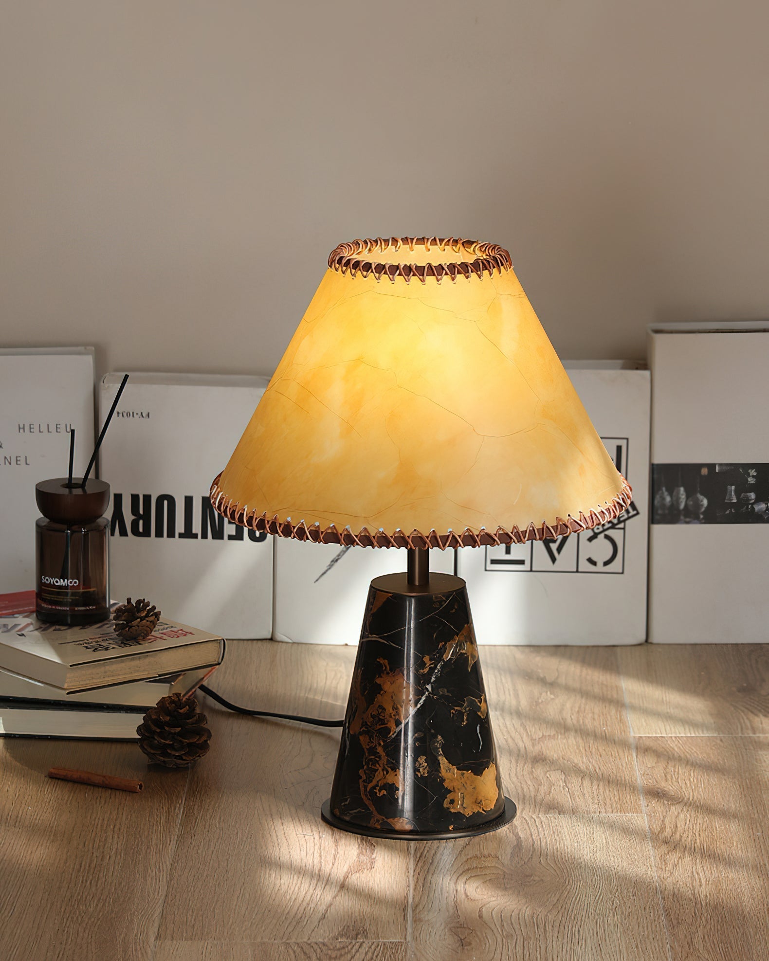 The lamp providing warm light on a bedroom nightstand.