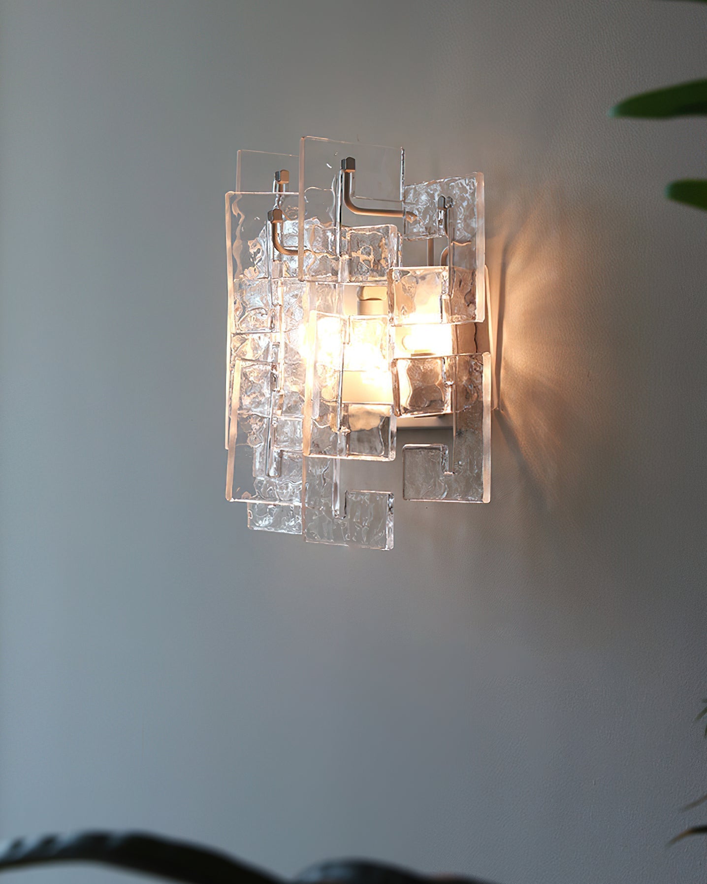 Stagger Cast Glass Sconce in Clear finish against a light wall.