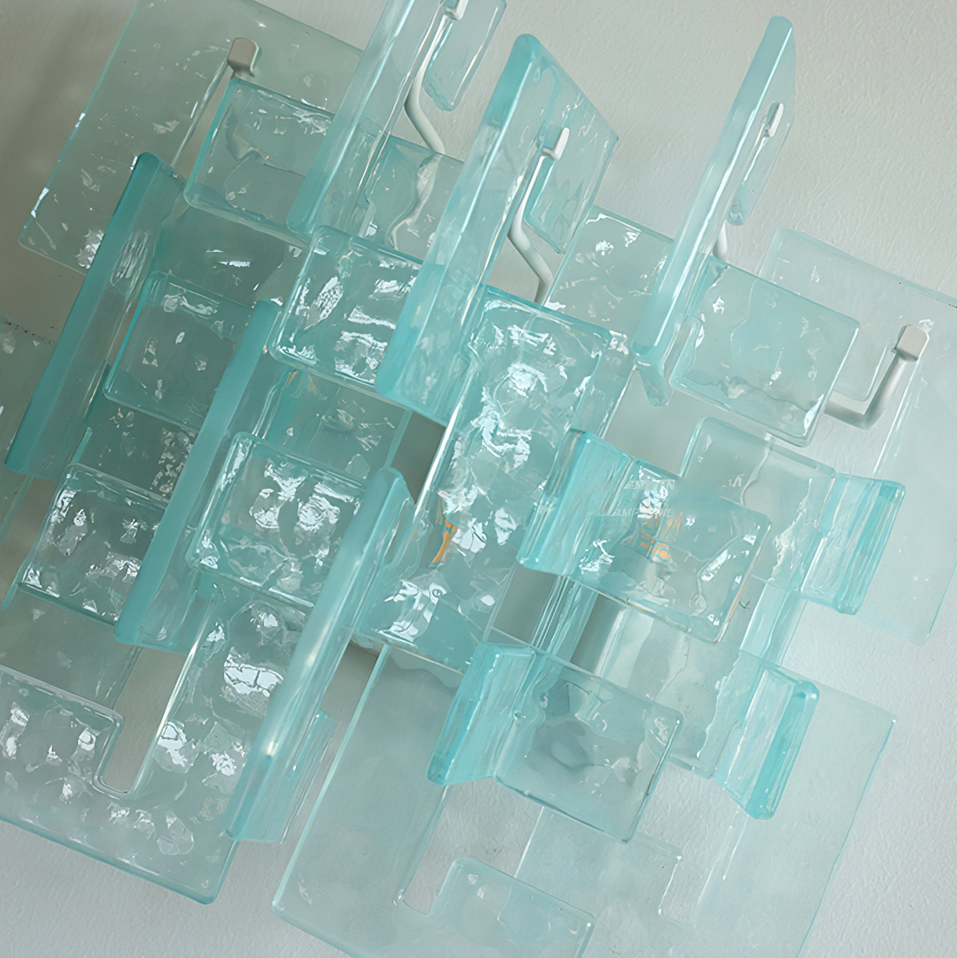 Front view of the Stagger Cast Glass Sconce in Clear finish.