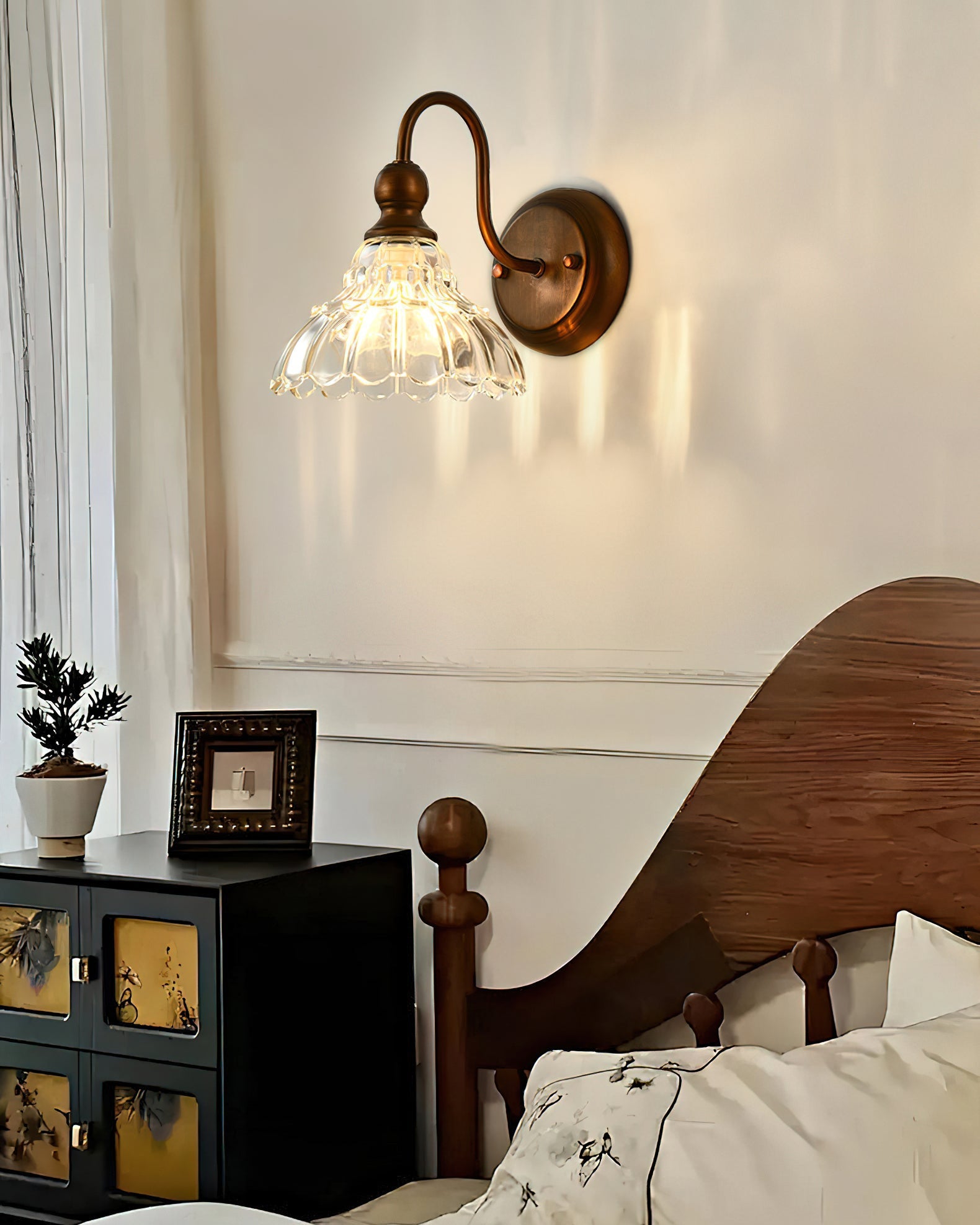 Sutton Glass Wall Sconce installed in a traditional bathroom setting above a sink.