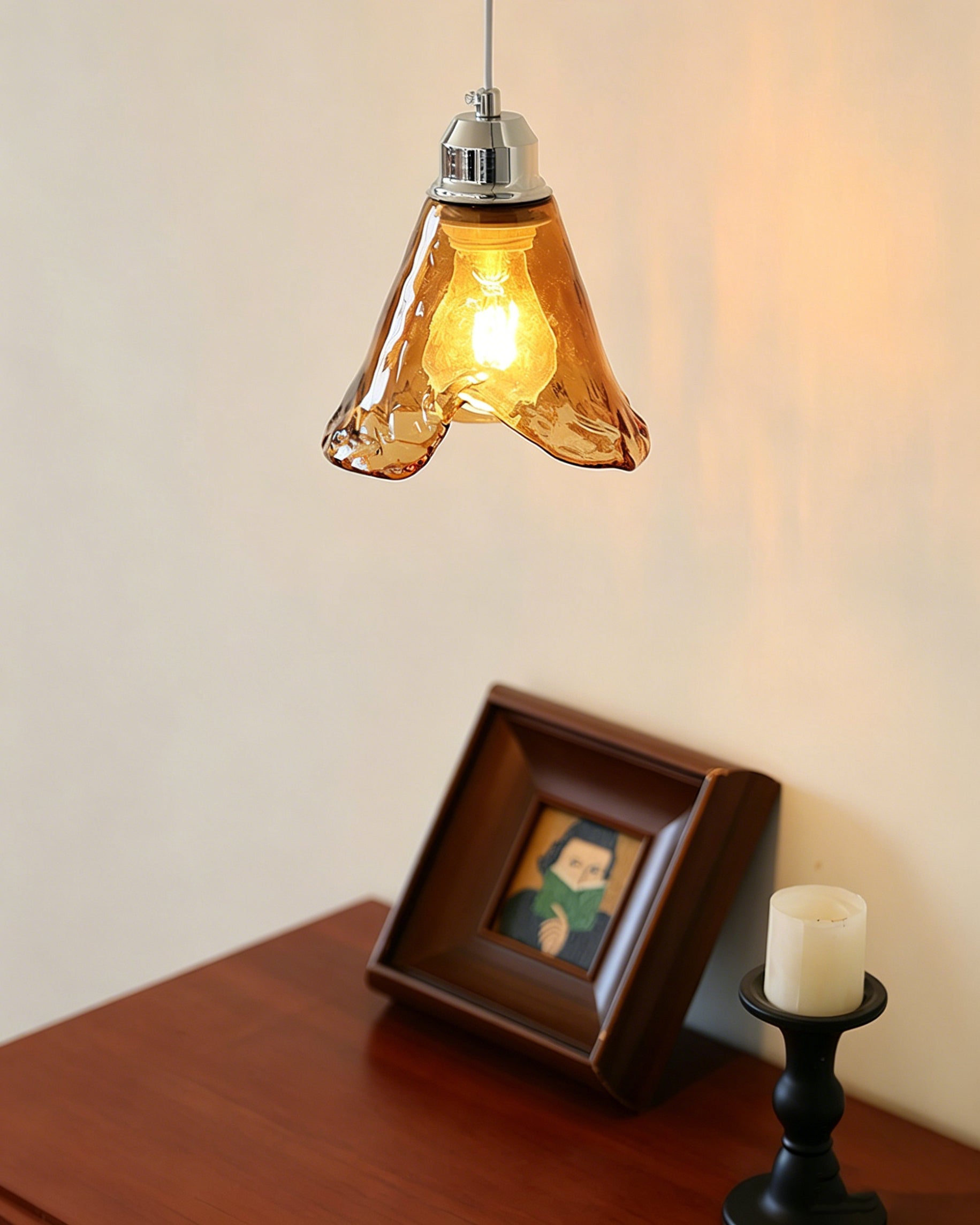 Angled view of the single Tiro Pendant Light, highlighting the contrast between the glass and metal.