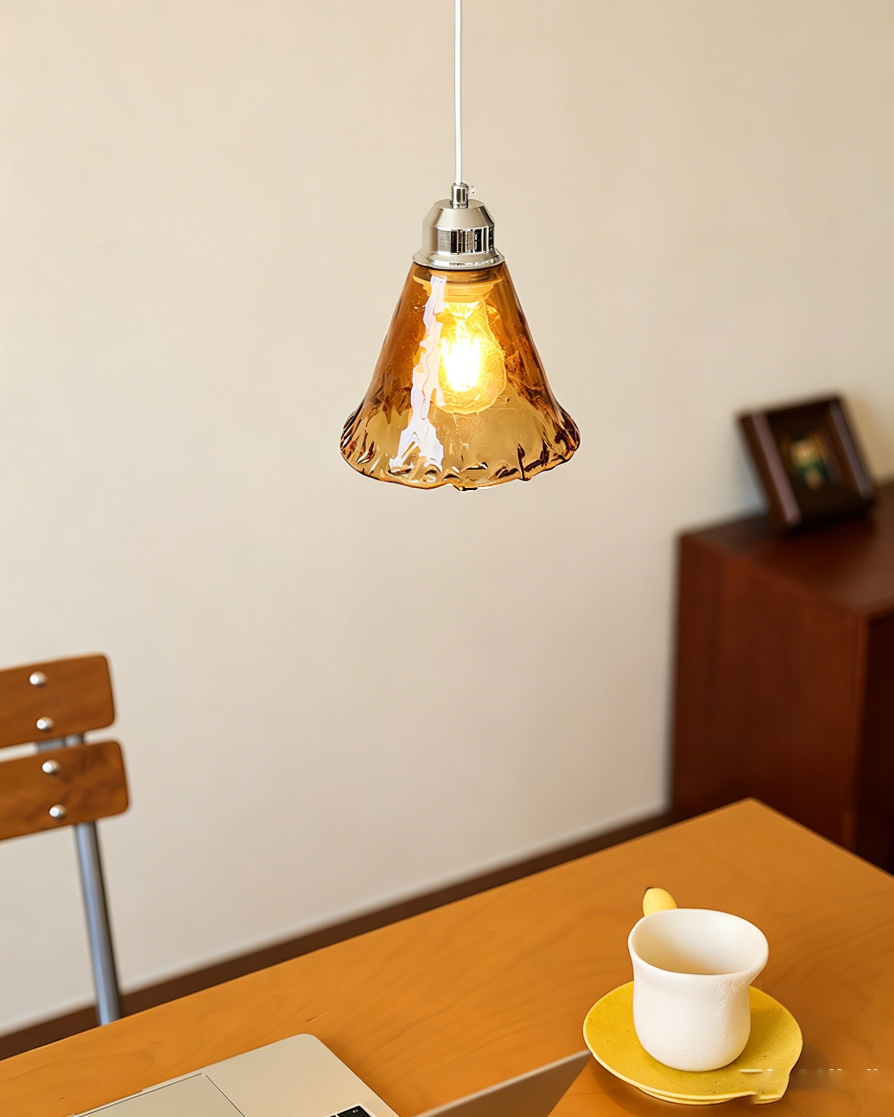 The Tiro Pendant Light shown unlit to display the rich amber color of the glass.