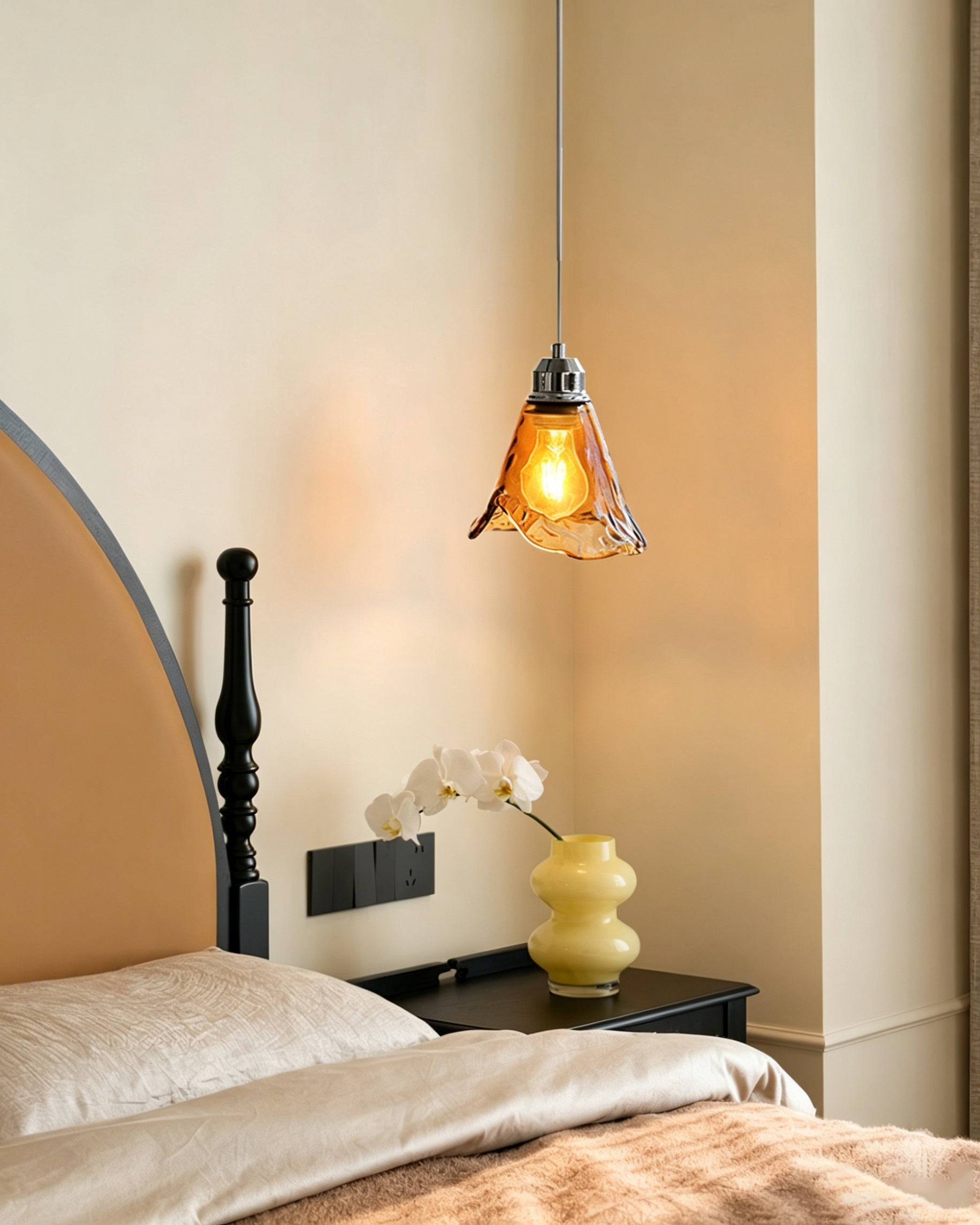The single-head Tiro Glass Pendant Light illuminating a cozy reading nook.
