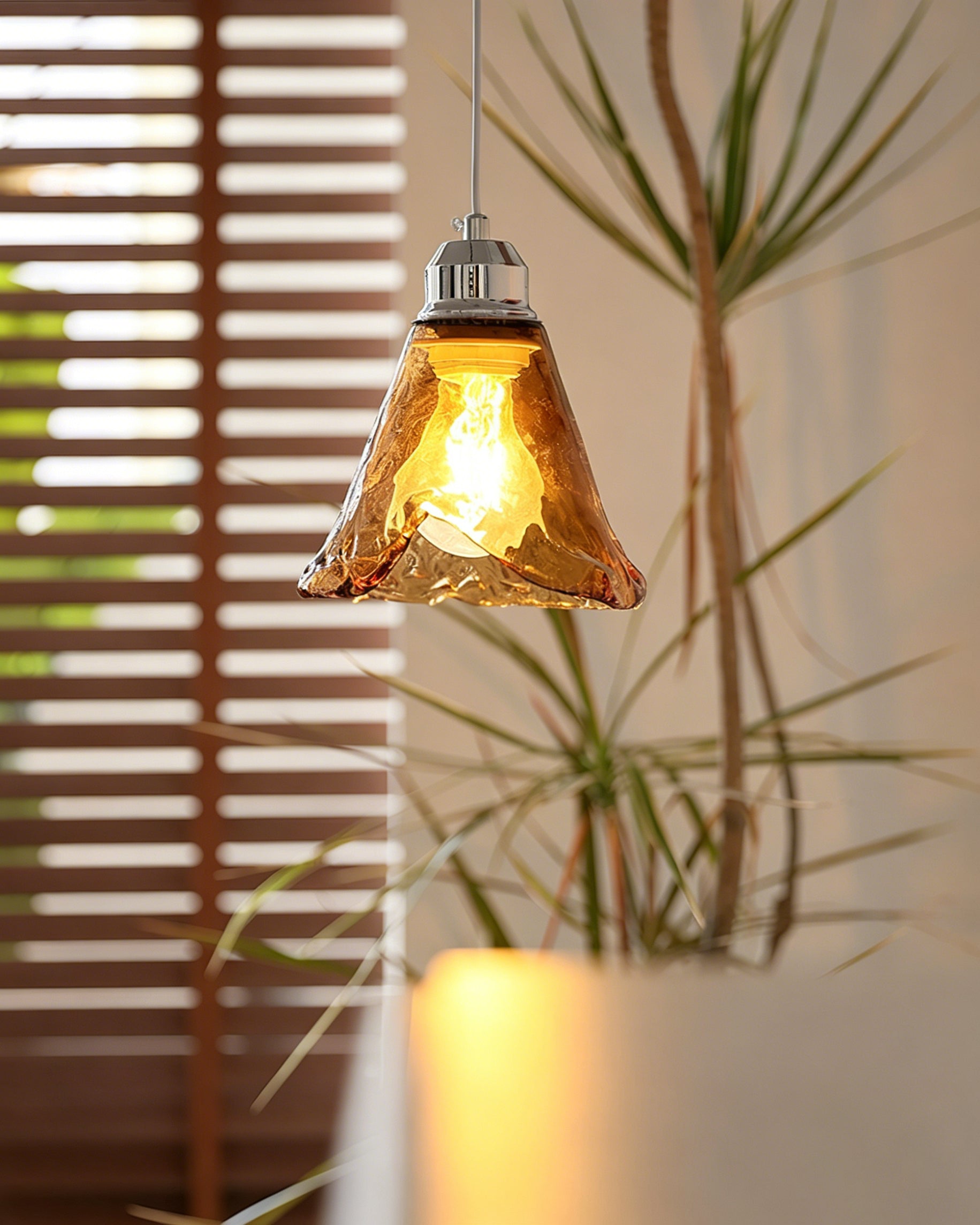 Lifestyle image of the Tiro Glass Pendant Light in a contemporary living room setting.
