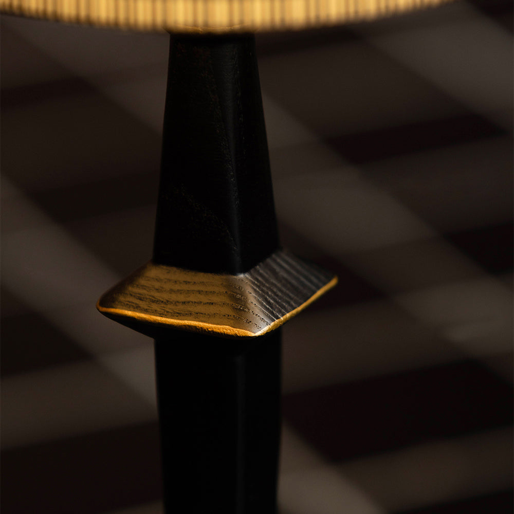 The contrast between the black iron and natural wood base.
