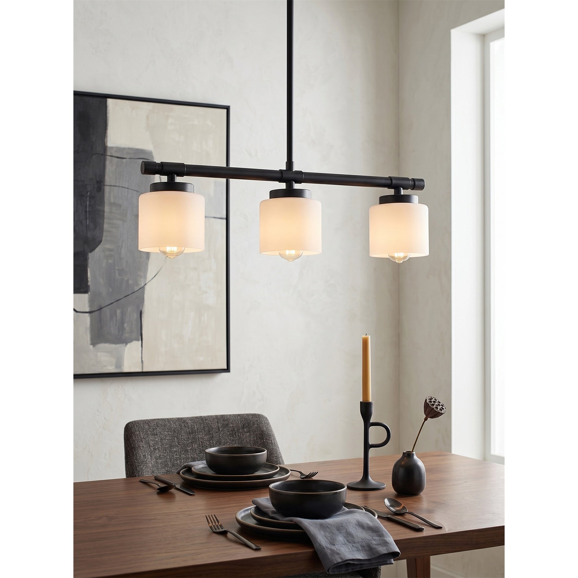The 3-light linear pendant casting a warm, ambient glow.