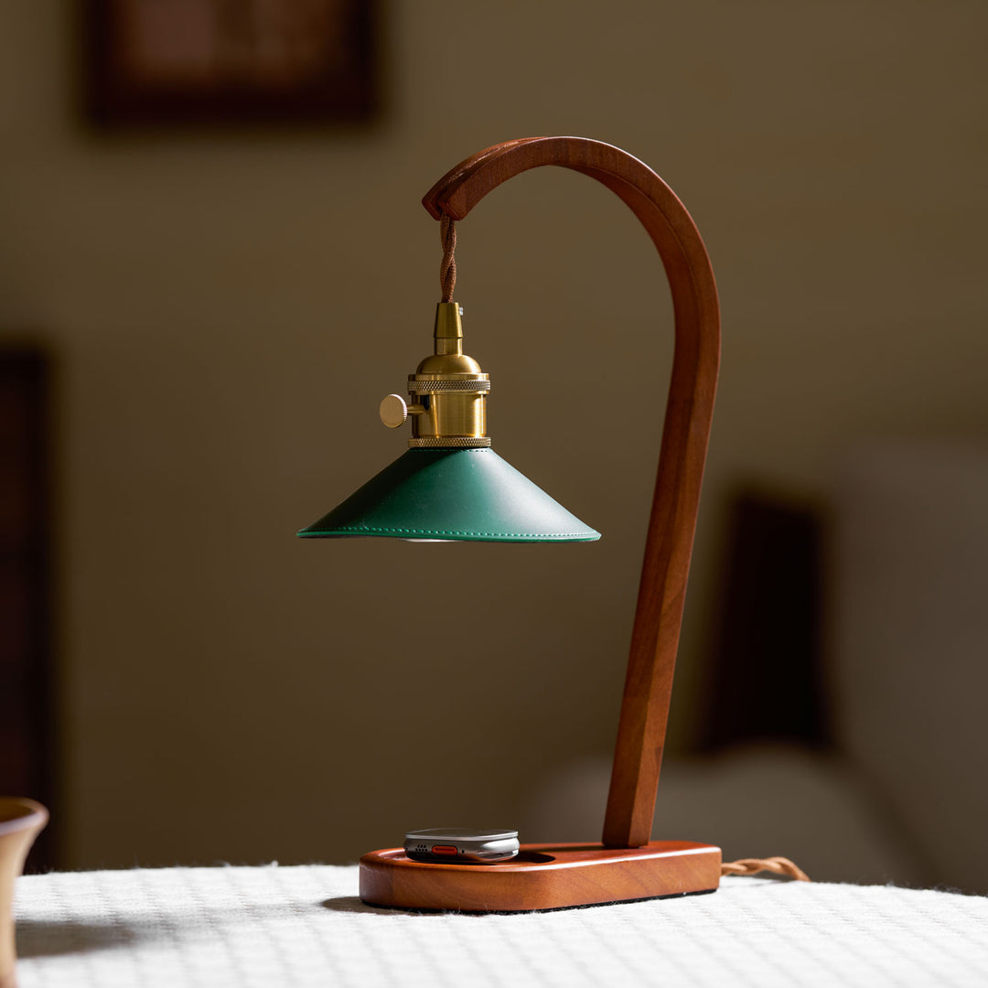 Lifestyle image featuring the lamp on a desk with books and decor.