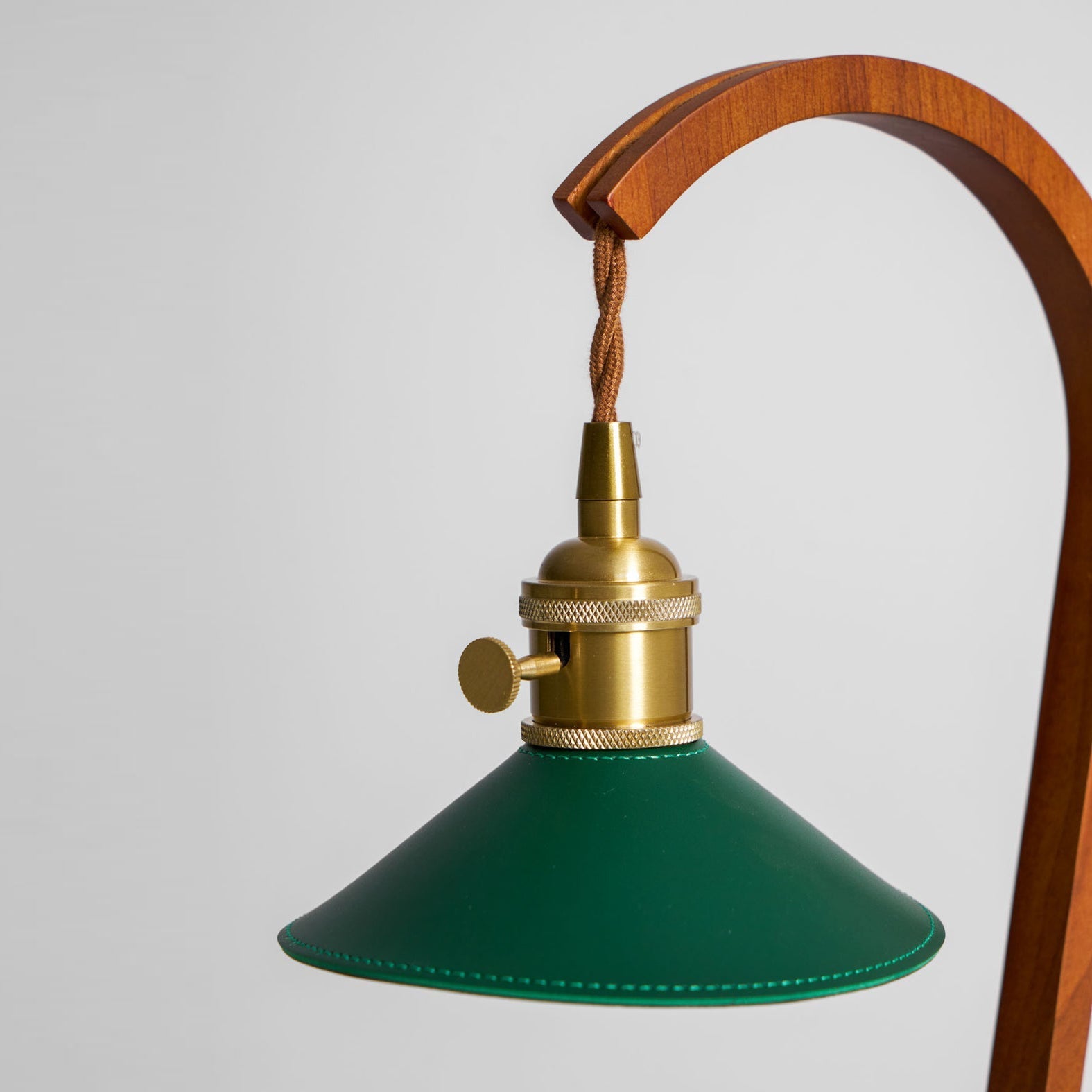An exploded view showing the lamp's components: wood, metal, and leather.