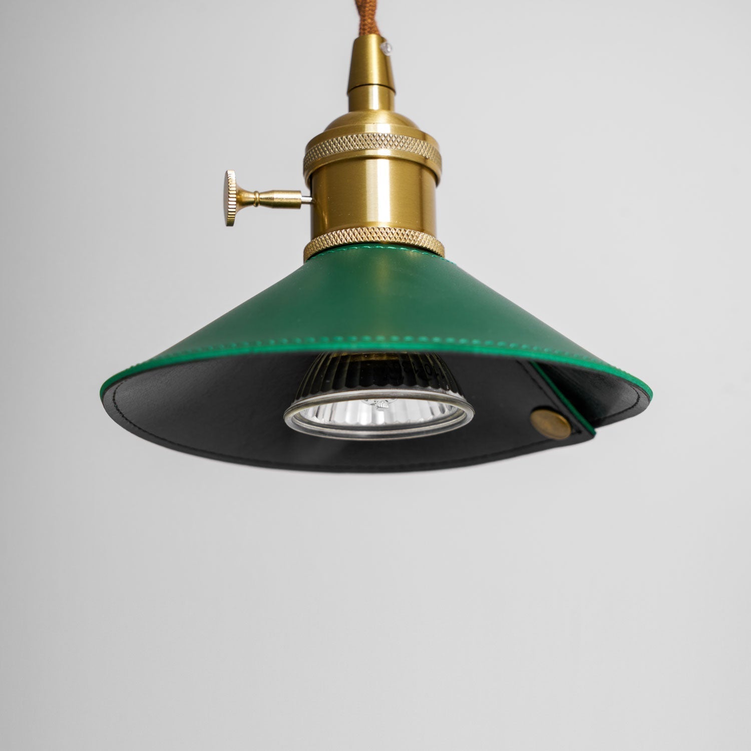 The lamp turned on, with light emanating from the shade.