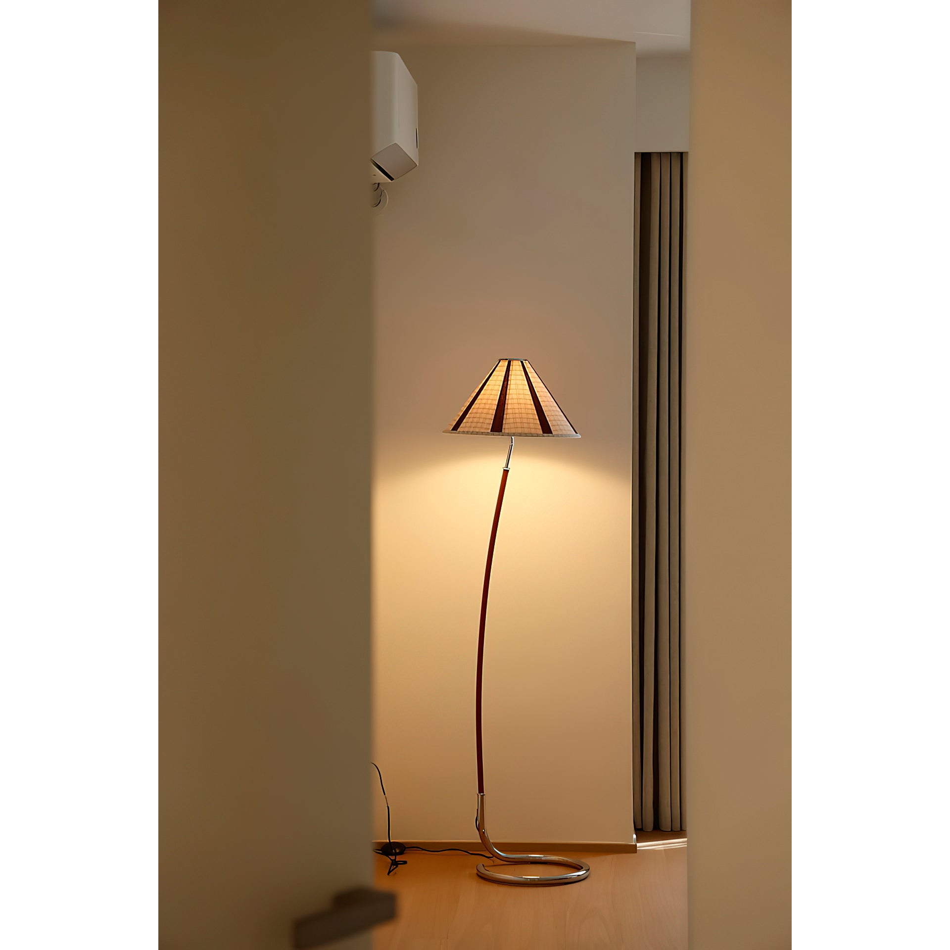 Lifestyle image of the lamp illuminating a cozy reading nook.