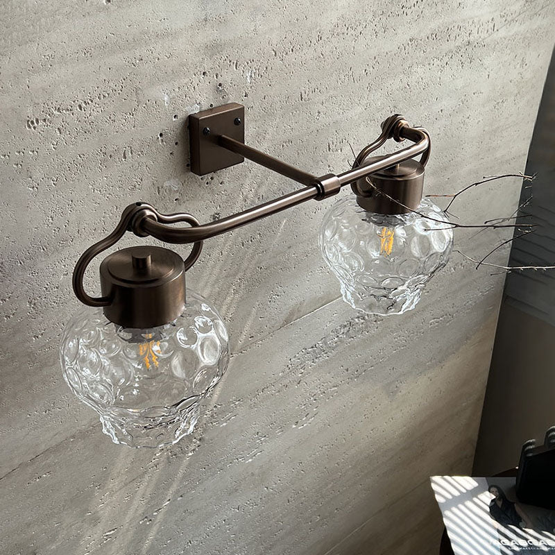 Close-up of the Eldorado Wall Lamp's glass lampshade and metal body.