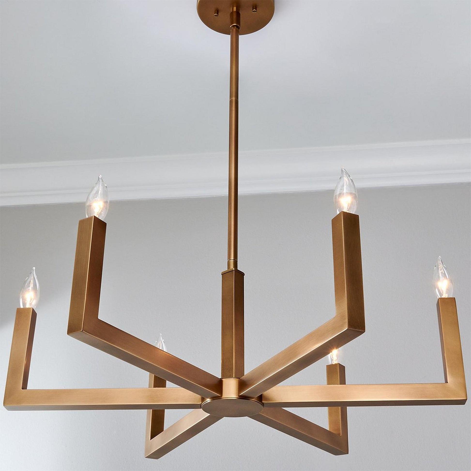 Close-up view of the Eliza Chandelier's brass arms and E12 sockets.