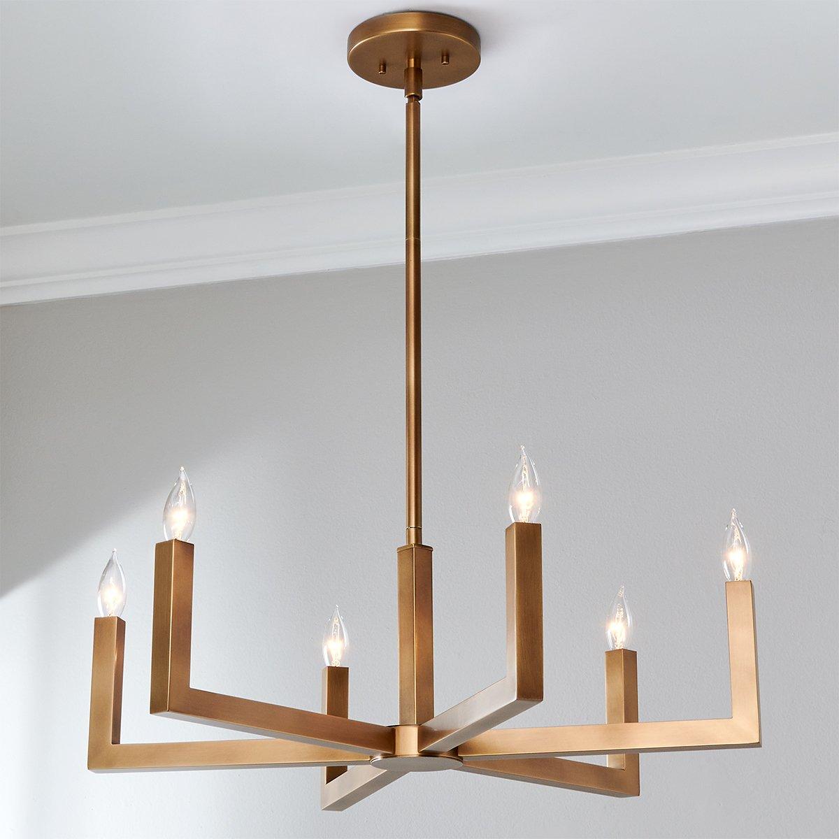 Lifestyle view of the Eliza Brass Chandelier installed above a dining table.