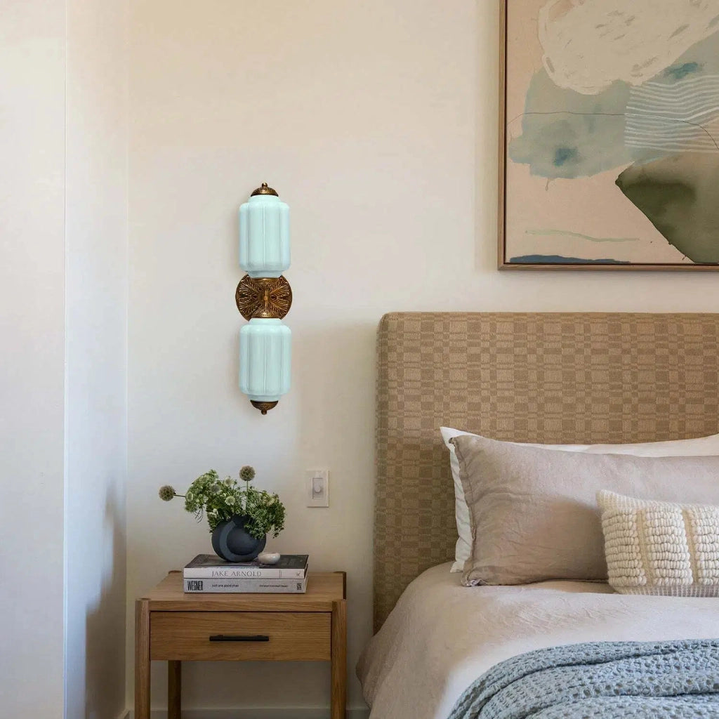 Eloise Sconce installed in a bathroom next to a mirror.