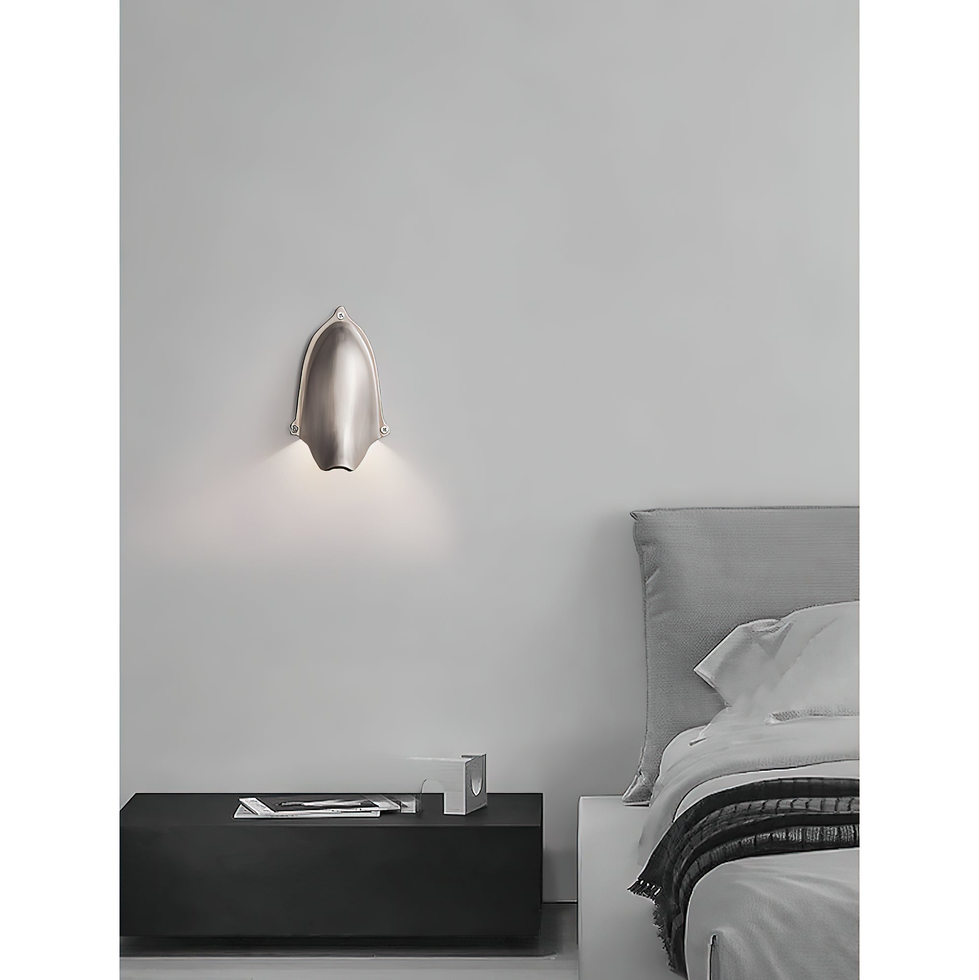 Enoki Wall Lamp in Antique Brass, casting a warm glow.