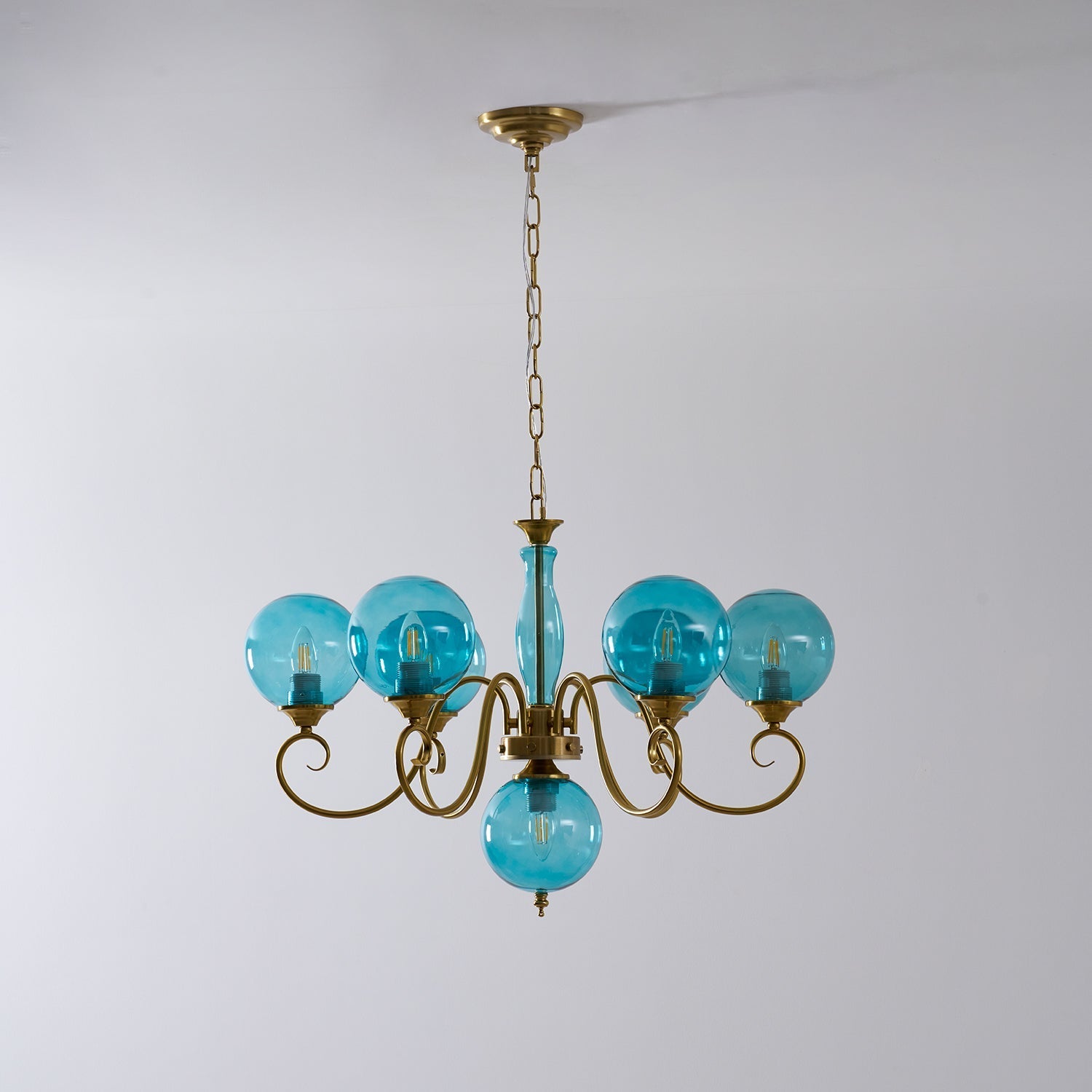 The warm light from the chandelier illuminating a room at dusk.