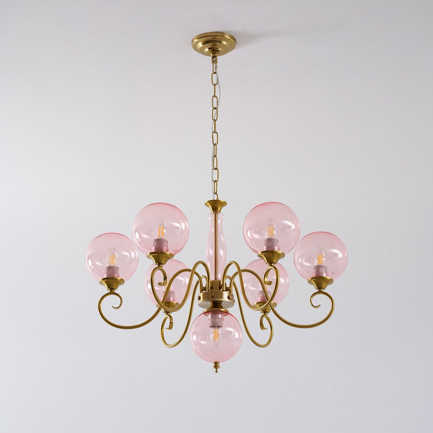 The 5+1 head chandelier hanging above a round dining table.