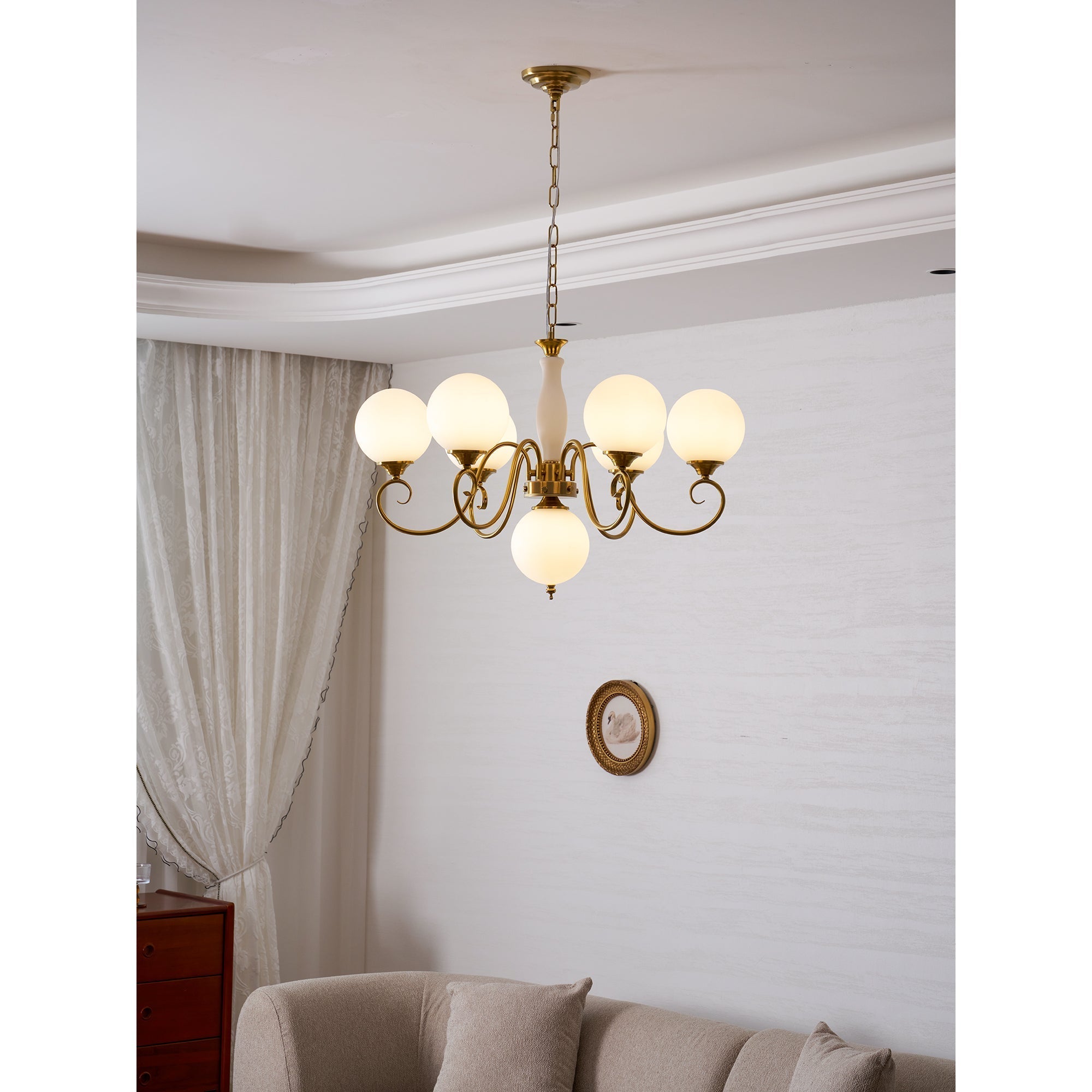 Evelyn Glass Chandelier with blush pink globes, illuminated.