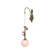Evelyn Glass Rose Wall Sconce in pink against a neutral wall.