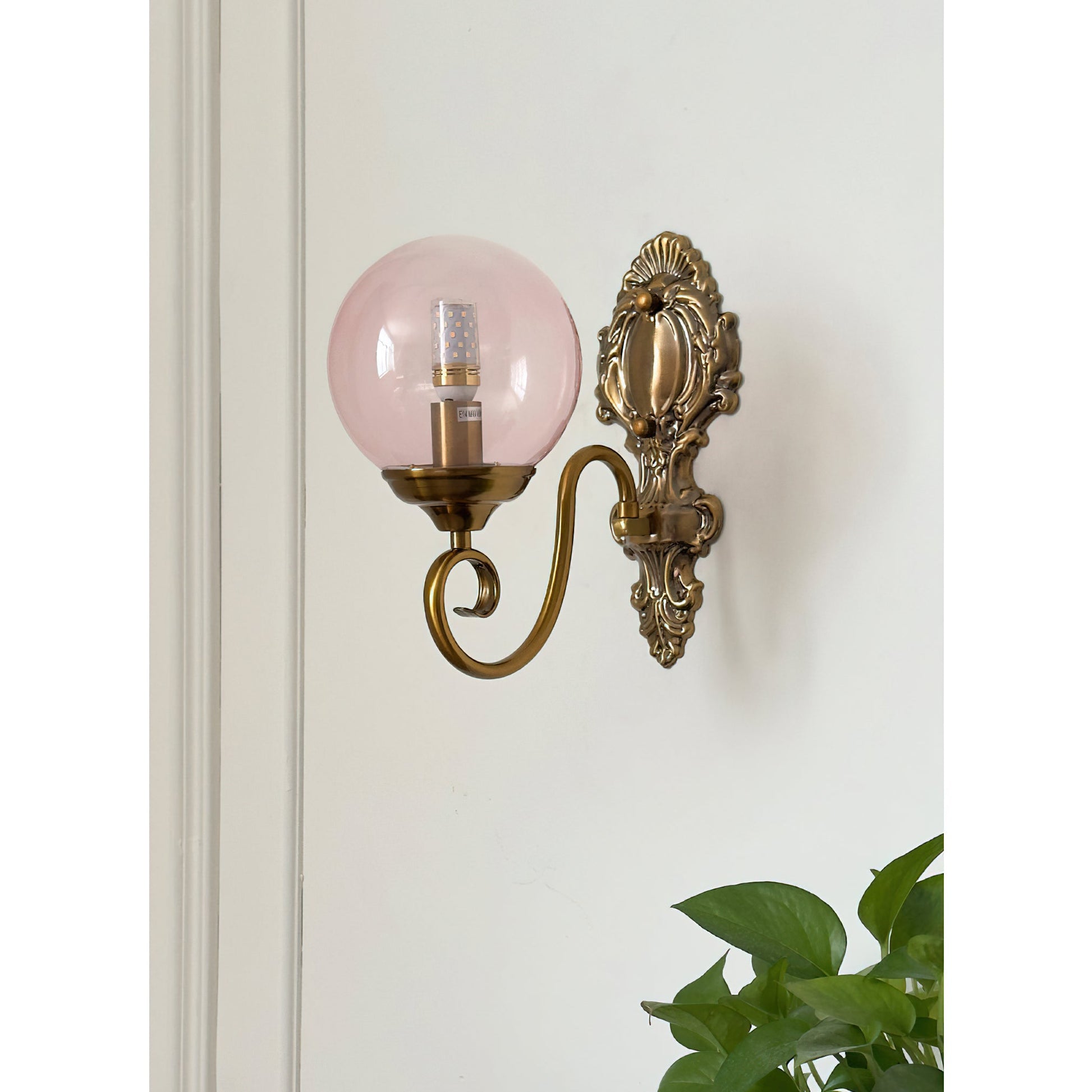 Evelyn Glass Wall Lamp in a bedroom setting above a nightstand.