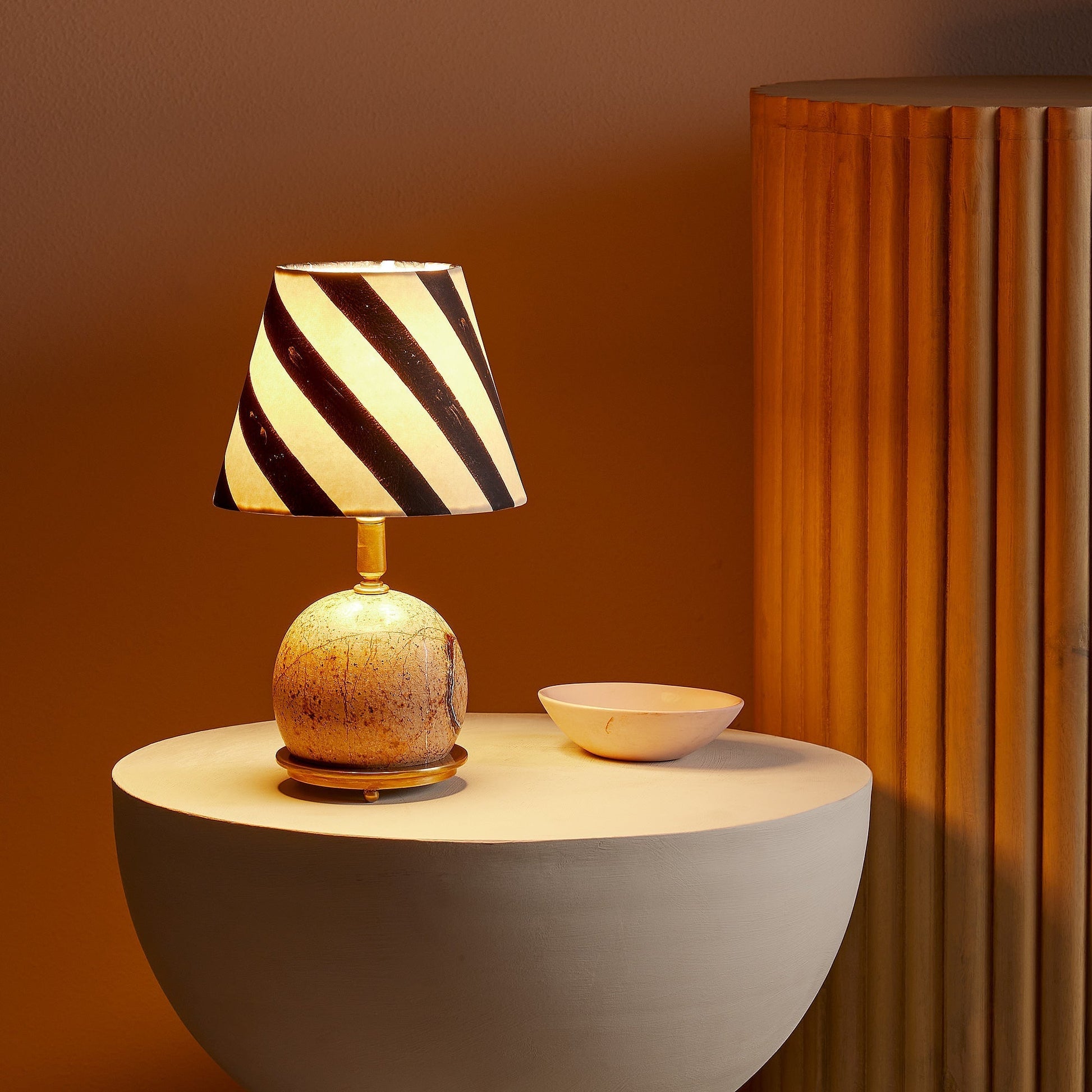 The Ferdy Table Lamp shown in the Black and White marble finish.