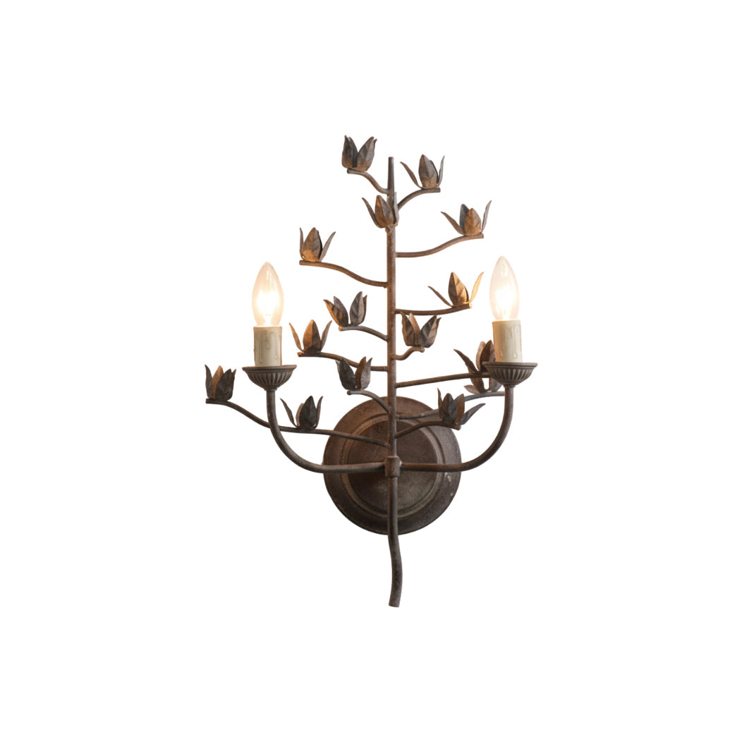 Ferroarte Branch Wall Lamp in a rust finish against a plain wall.