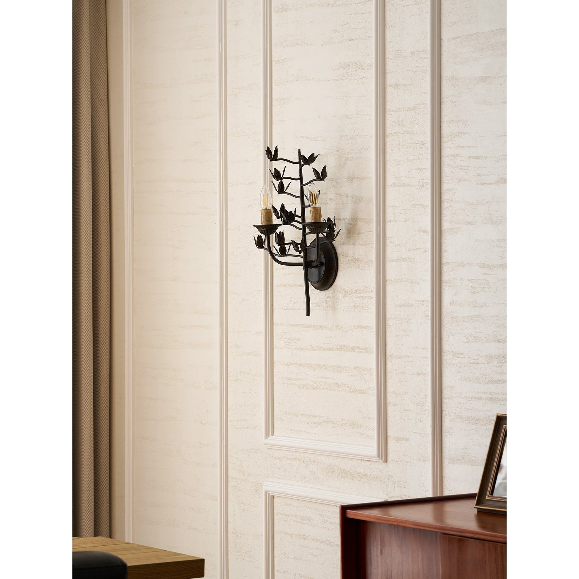 The two light heads of the branch wall lamp, illuminated.