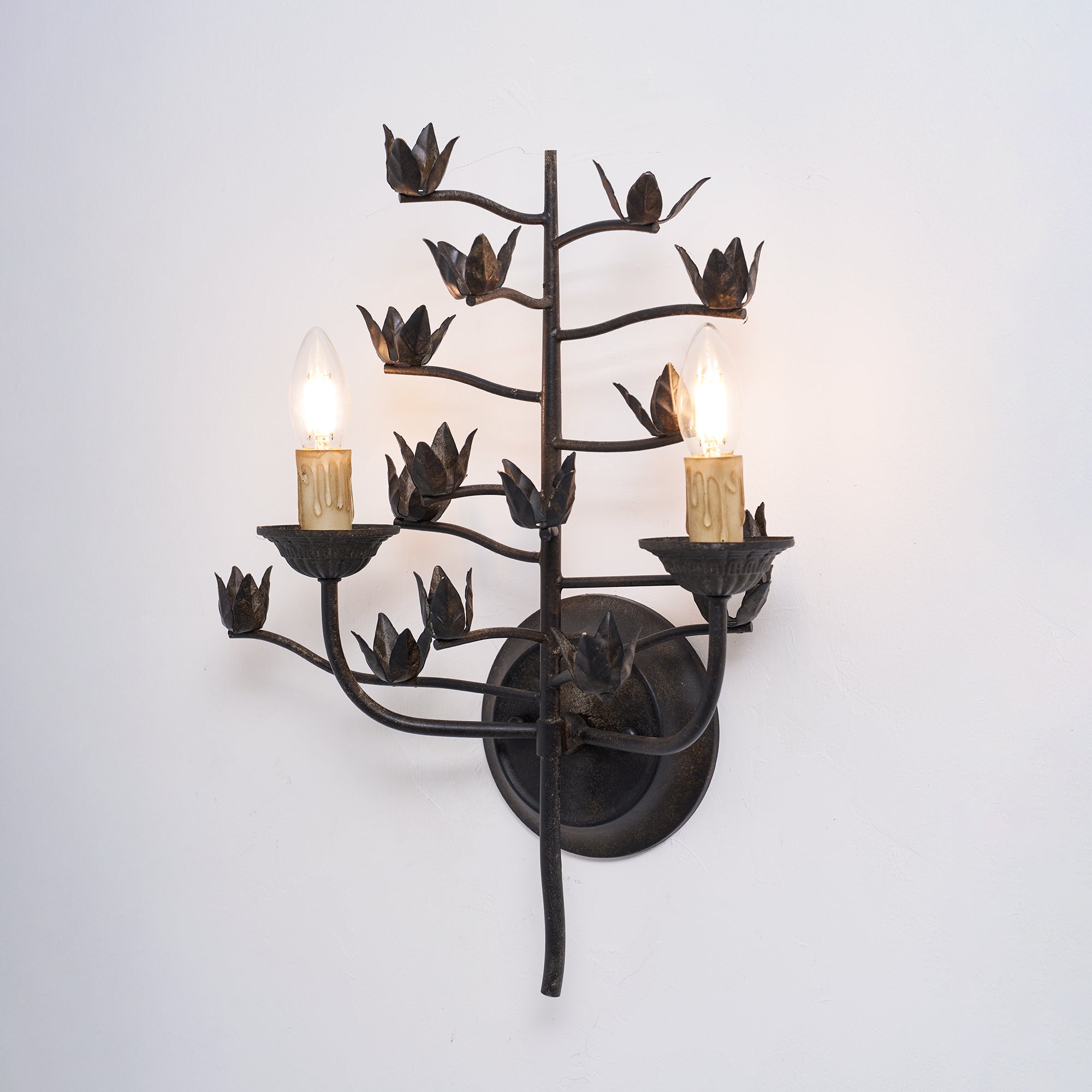 The lamp's sculptural form against a textured wall.