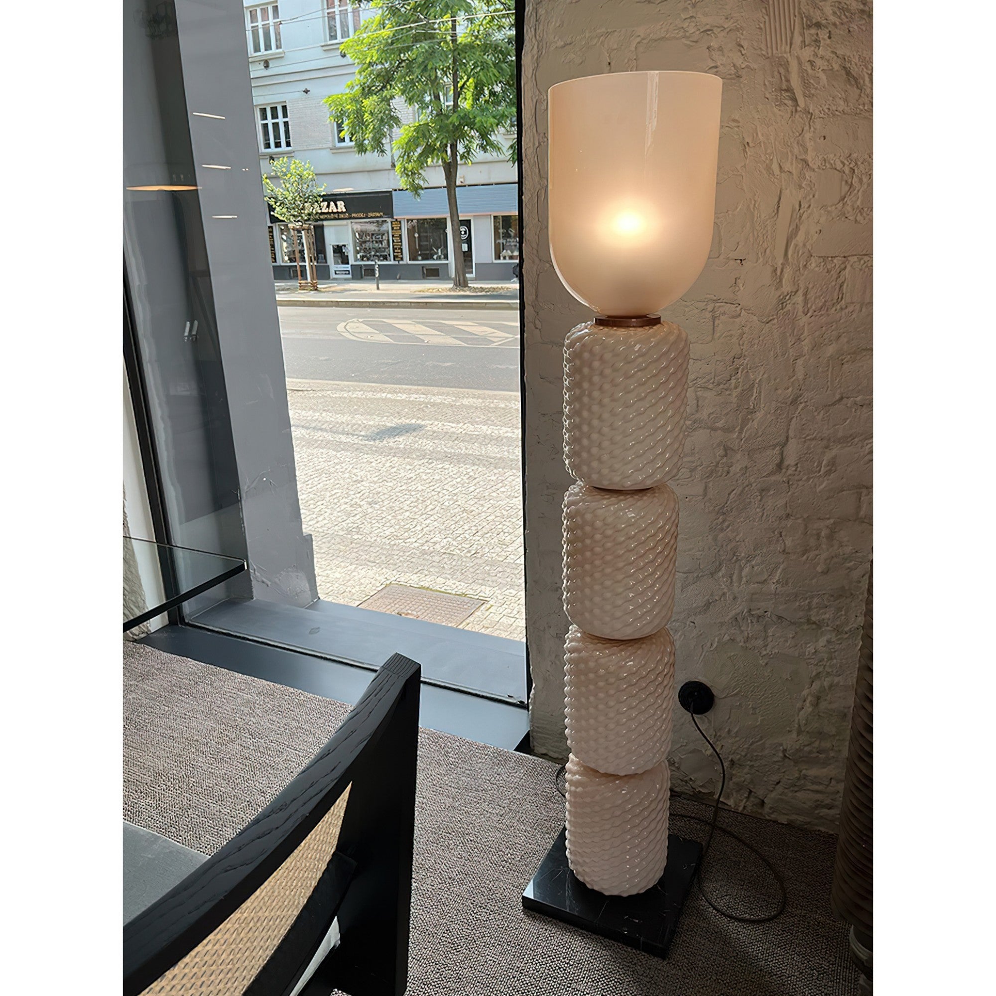 The Ficupala floor lamp illuminated, casting a warm and inviting glow.